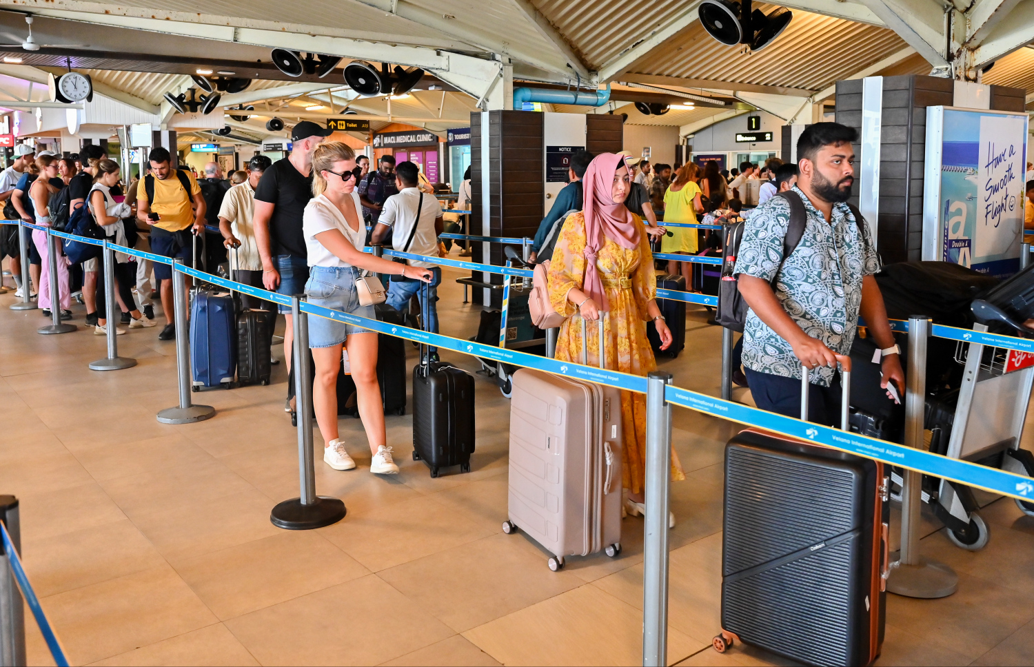 ވެލާނާ އެއާޕޯޓުގެ އިންޓަނޭޝަނަލް ޓާމިނަލުން ދަތުރުކުރާ މީހުން ކިޔޫގައި: މިއީ އެ އެއާޕޯޓުން މި އަހަރު އެންމެ ގިނަ މީހުން ދަތުރުކުރާ އެއް ދުވަސް.-- ފޮޓޯ: ނިޝާން އަލީ | މިހާރު