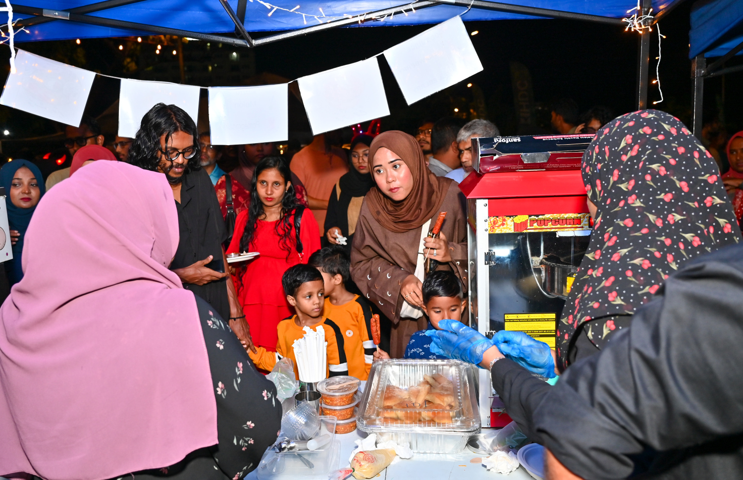 ރާއްޖެ އިން 2025 ވަނަ އަހަރަށް މަރުހަބާ ކިޔަން މޯލްޑިވްސް ކަލްޗާ އެންޑް ފުޑް ފެސްޓިވަލްގެ ނަމުގައި ސެންޓްރަލް ޕާކުގައި ކުރިއަށް ގެންދާ ހަރަކާތުގައި ބަހައްޓާފައިވާ ސްޓޯލެއްގެ ކައިރީގައި ބަޔަކު ހަރަކާތްތެރިވަނީ.---ފޮޓޯ: ނިޝާން އަލީ| މިހާރު