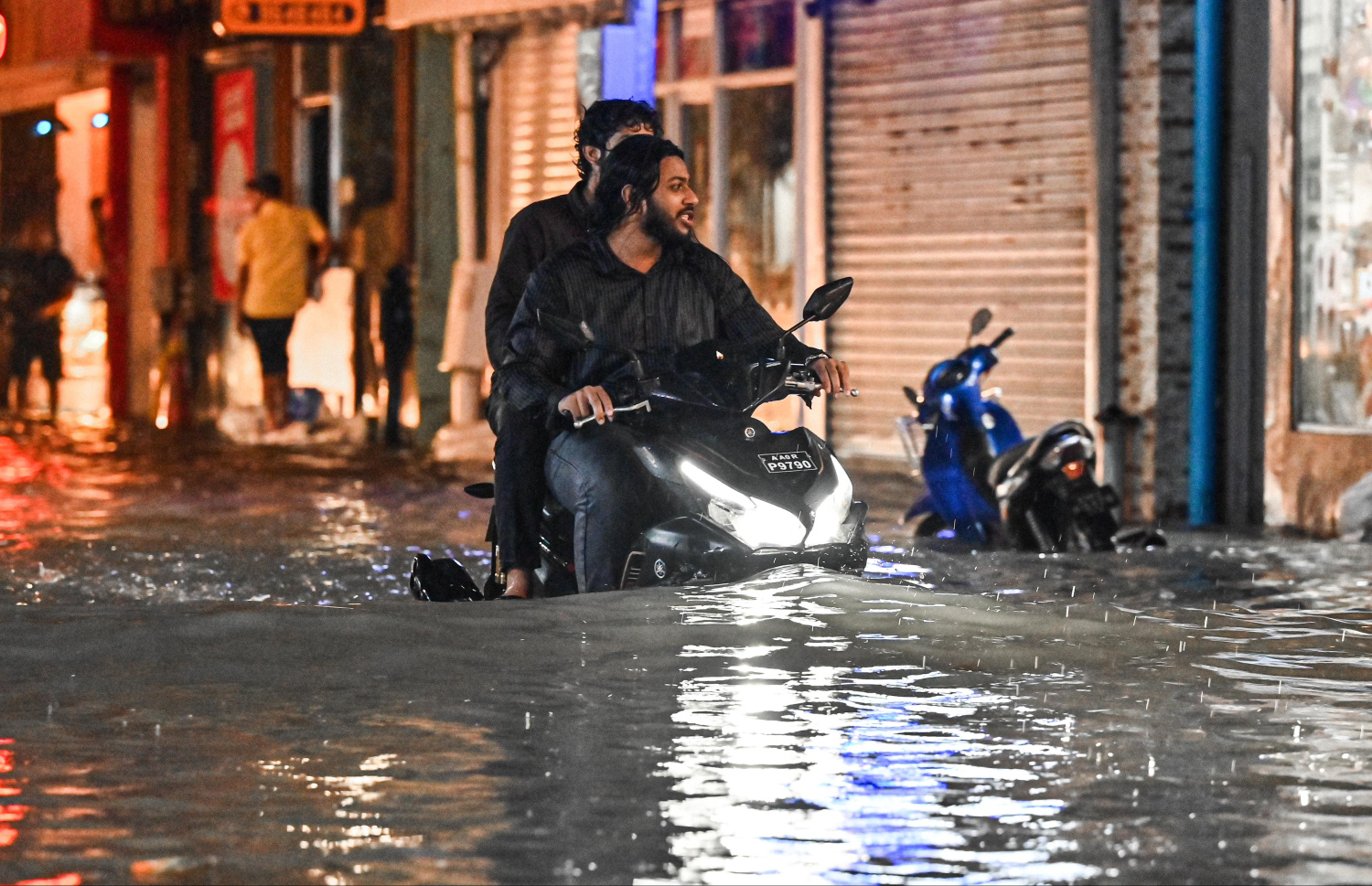 ބޯކޮށް ވާރޭވެހި މަގެއްގައި ފެންބޮޑުވެފައި ވަނިކޮށް މީހަކު ސައިކަލެއްގައި ދަނީ.-- ފޮޓޯ: ނިޝާން އަލީ | މިހާރު