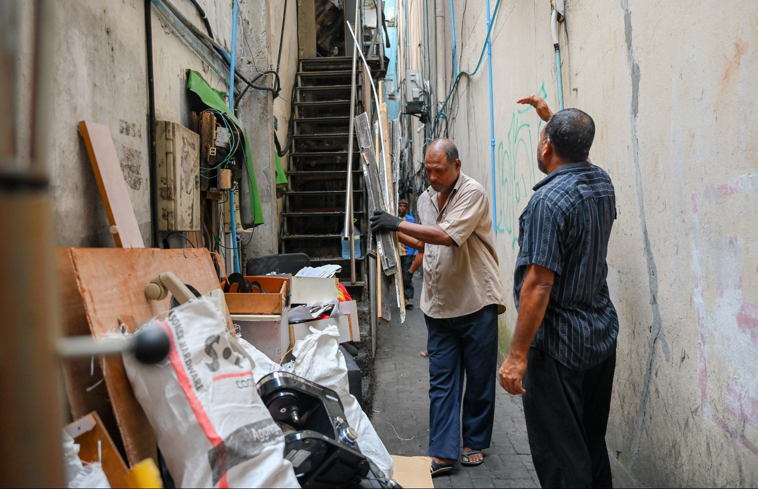 މަޖީދީމަގުގައި ހުންނަ ފުރުޓް ޓްރީ އެޕަލް ފިހާރައިން ސަލާމަތްކުރެވުނު މުދާ އެތަނުން ނެރެނީ.-- ފޮޓޯ: ނިޝާން އަލީ | މިހާރު