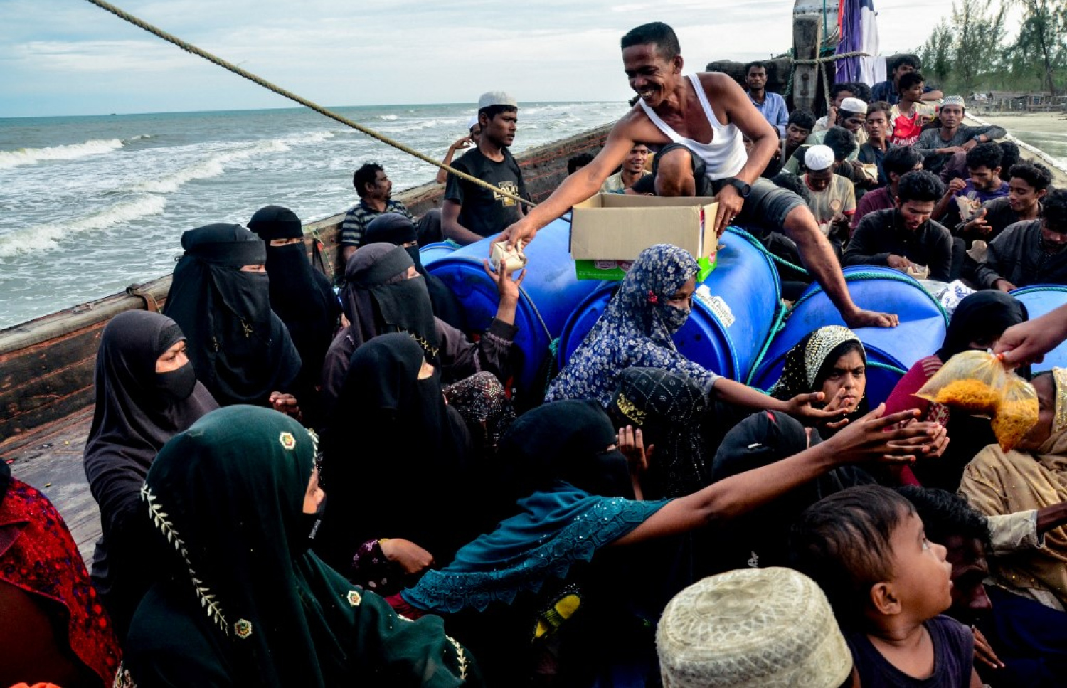 އިންޑޮނީޝިއާއަށް އިއްޔެ ދިޔަ މިއަންމާގެ ރޮހިންޖާއިންނަށް އާންމުން ކާބޯތަކެތި ދެނީ. -- ފޮޓޯ: އޭއެފްޕީ