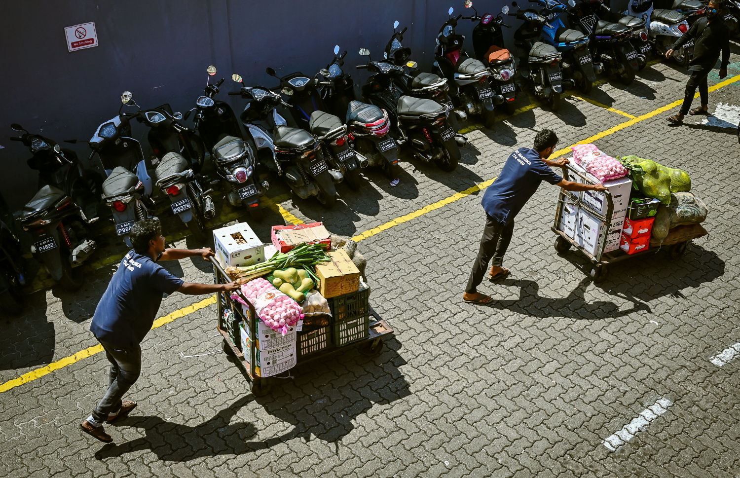 ލޯކަލް މާރުކޭޓު ކައިރިން މީހަކު ޓްރޯލީއެއްގައި މުދާ ތަކެއް ގެންދަނީ.-- ފޮޓޯ: ނިޝާން އަލީ | މިހާރު