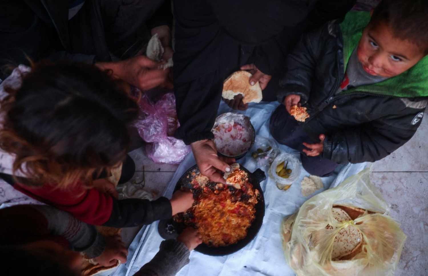 މި އަހަރުގެ ރަމަޟާން މަހުގެ ފުރަތަމަ ދުވަހު ފަލަސްތީނުގެ އާއިލާއަކުން ރޯދަ ވީއްލަނީ: ރޯދަ މަސް ފެށުނު އިރު ޣައްޒާގެ ރައްޔިތުން ތިބީ އިޒްރޭލުގެ ހަމަލާތަކުގެ ސަބަބުން ހާލުގައި ޖެހިފައި. -- ފޮޓޯ: އޭއެފްޕީ