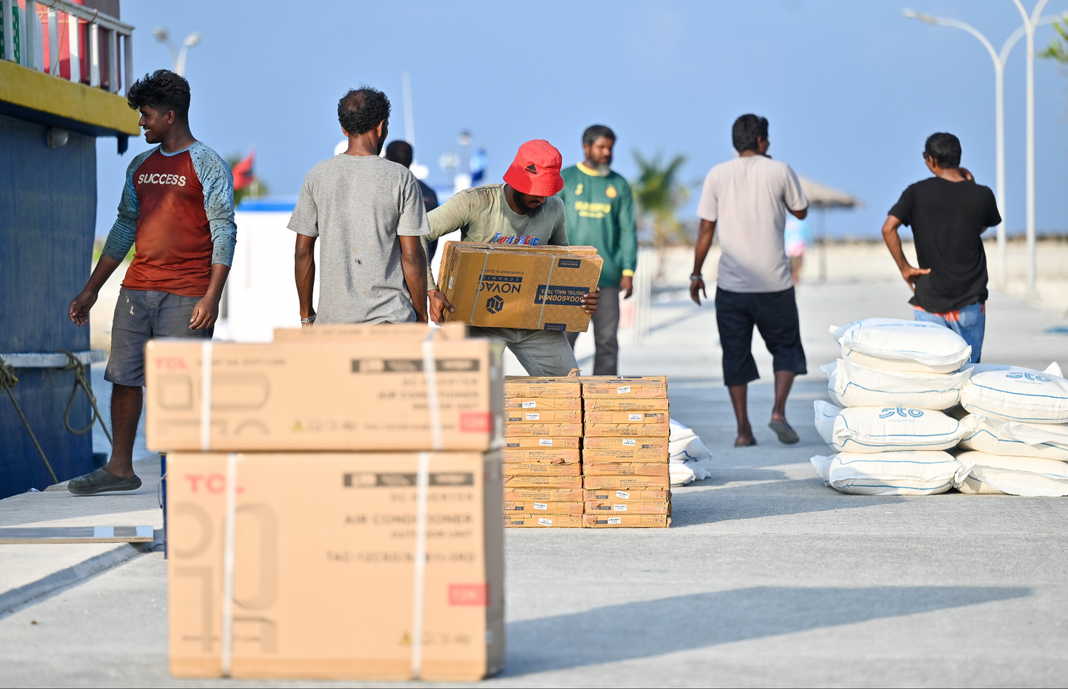 ހެނބަދޫގެ ބަންދަރުމަތީގައި ބަޔަކު ފޮށިތަކެއް އުފުލަނީ.---ފޮޓޯ: ފަޔާޒު މޫސާ| މިހާރު