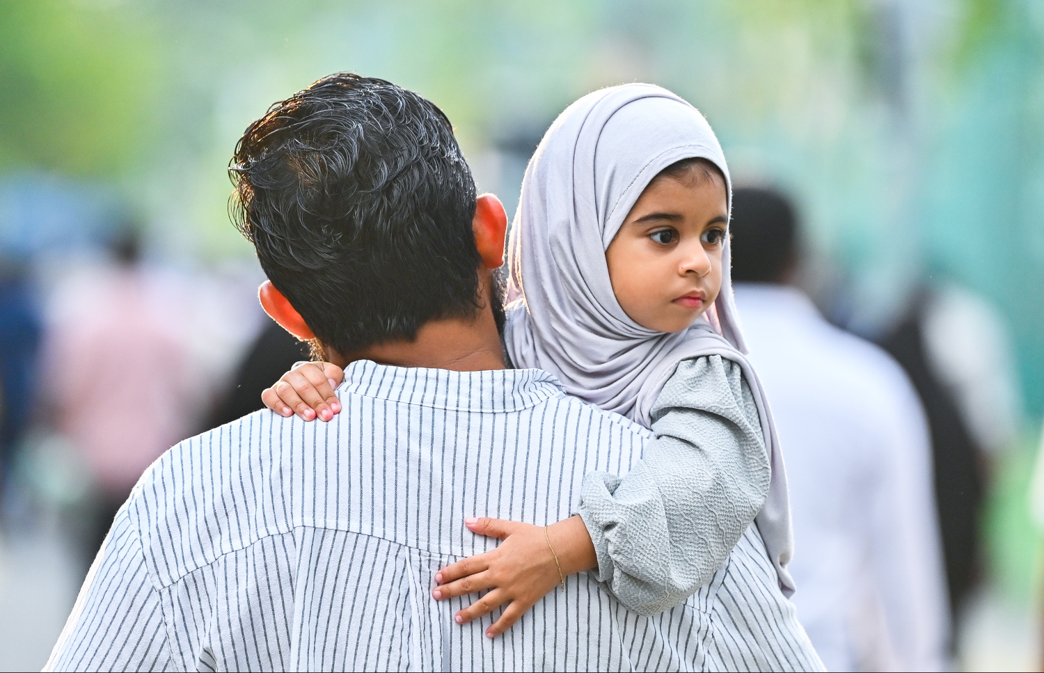 މާލޭގައި ބޮޑު ޖަމާއަތުގައި އޮތް އީދު ނަމާދުކުރާ މައިދާނަށް ދިޔަ މީހަކު ކުއްޖަކު އުރާލައިގެން. -- ފޮޓޯ: ފަޔާޒު މޫސާ \ މިހާރު