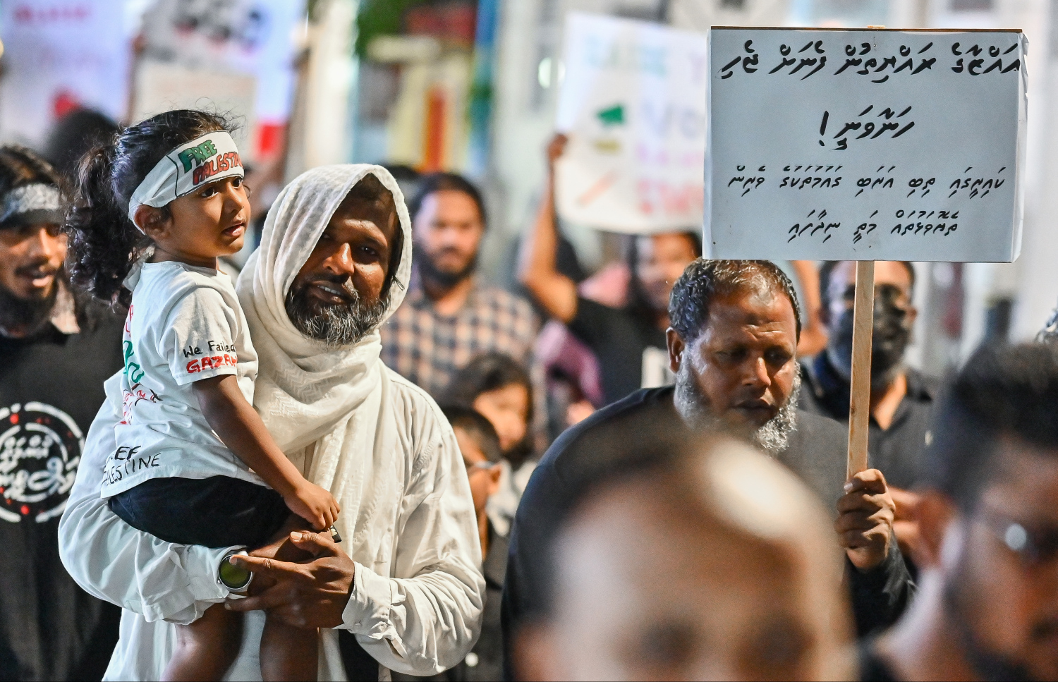 "އުންމަތް ފަލަސްތީނާ އެކު" ނަމުގައި މާލޭގައި ބޭއްވި ބޮޑު ހިނގާލުމަށް ގެންދިޔަ ކުޑަކުއްޖަކު އުރާލައިގެން ދަނީ: މި ހަރަކާތުގައި ގިނަ ބަޔަކު ވަނީ ބައިވެރިވެފައި.--- ފޮޓޯ: ފަޔާޒު މޫސާ| މިހާރު