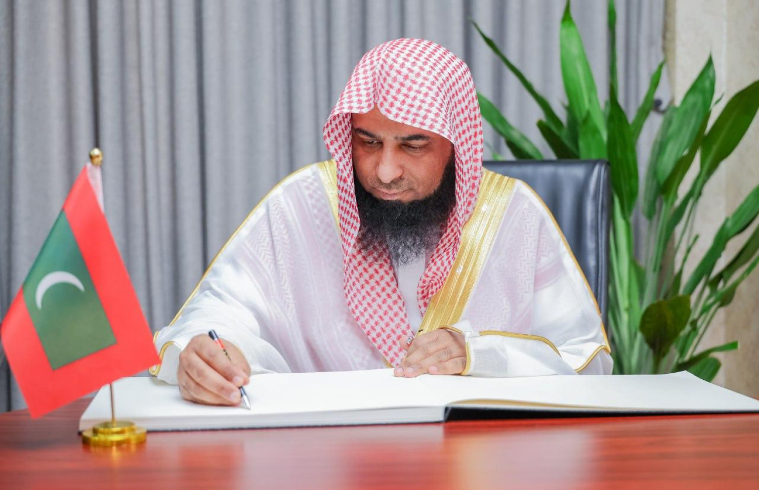 މަސްޖިދުއް ނަބަވީގެ އިމާމް އަދި ޚަތީބު ޑރ. ސަލާހުލްބުދައިރު ރާއްޖެއަށް ކުރައްވަމުން ގެންދަވާ ދަތުރުފުޅުގައި އިސްލާމީ މަރުކަޒަށް ކުރެއްވި ޒިޔާރަަތުގައި އިއްޒަތްތެރިން ސޮއި ކުރައްވާ ފޮތުގައި އިމާމް ސޮއި ކުރައްވަނީ --- ފޮޓޯ/އިސްލާމިކް މިނިސްޓްރީ