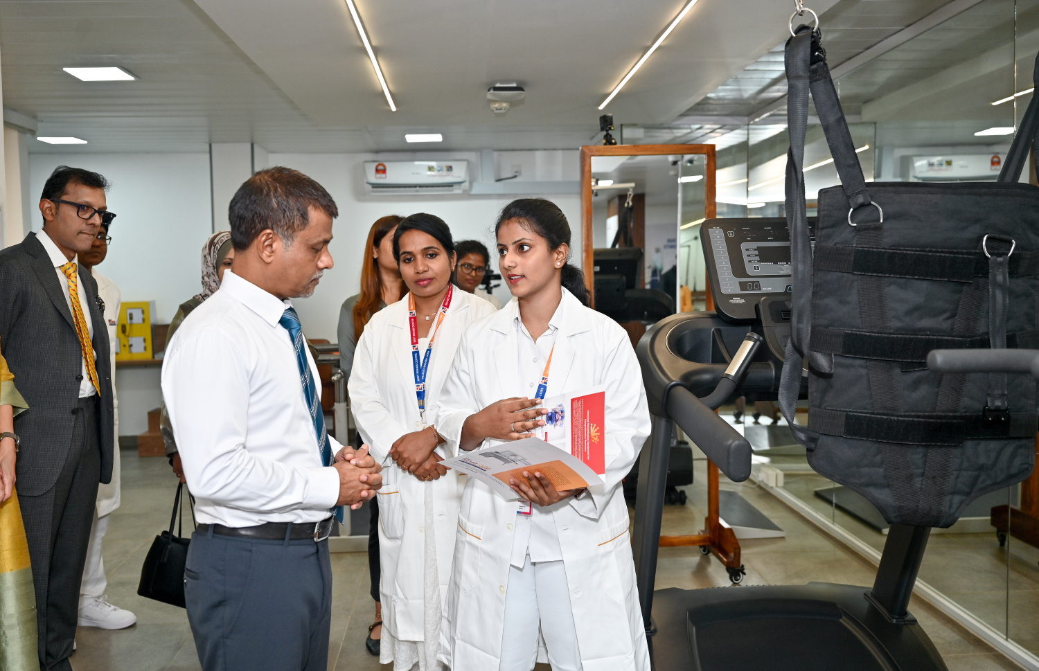 އިންޑިއާގެ "މިއޮޓް" ހޮސްޕިޓަލުން ރާއްޖޭގައި ހުޅުވި ދުނިޔޭގެ ފެންވަރުގެ ރިހެބިލިޓޭޝަން ސެންޓަރު ހެލްތު މިނިސްޓަރު ނާޒިމް ބައްލަވާލައްވަމުން އެ ތަނުގެ ބައެއް މުވައްޒަފުންނާ ވާހަކަ ދައްކަވަނީ: އެއީ އެންމެ ފަހުގެ ޓެކްނޮލަޖީގެ އެހީގައި ފަރުވާ ދީ، އާއްމު ދިރިއުޅުމަށް ރުޖޫއަވުމަށް ބޭނުންވާ ރިހެބިލިޓޭޝަން ދޭ ސެންޓަރެއް.-- ފޮޓޯ: ނިޝާން އަލީ | މިހާރު