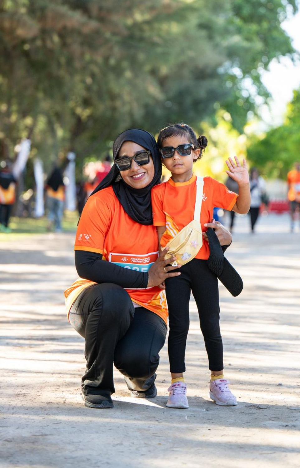 ދިރާގު ފުވައްމުލައް ރަންގައި ބައިވެރިވި މީހަކު ކުޑަކުއްޖަކާ އެކު ފޮޓޯއަކަށް ހުއްޓިލައިގެން -- ފޮޓޯ: ދިރާގު