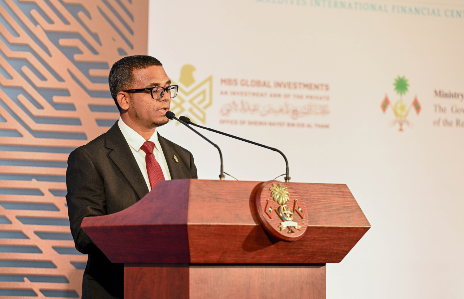 ދިވެހި ސަރުކާރާއި އެމްބީއެސް ގްލޯބަލްއާ ދެމެދު މޯލްޑިވްސް އިންޓަނޭޝަނަލް ފައިނޭންޝަލް ސެންޓަރު ގާއިމުކުރުމުގެ އެއްބަސްވުމުގައި ސޮއިކުރުމަށް ބޭއްވި ރަސްމިއްޔާތުގައި އެމްއެމްއޭގެ ގަވަރުނަރު އަހުމަދު މުނައްވަރު ވާހަކަ ދައްކަވަނީ. މިއީ 8.8 ބިލިއަން އެމެރިކާ ޑޮލަރުގެ ބިޔަ މަޝްރޫއެއް.--- ފޮޓޯ: ރައީސް އޮފީސް