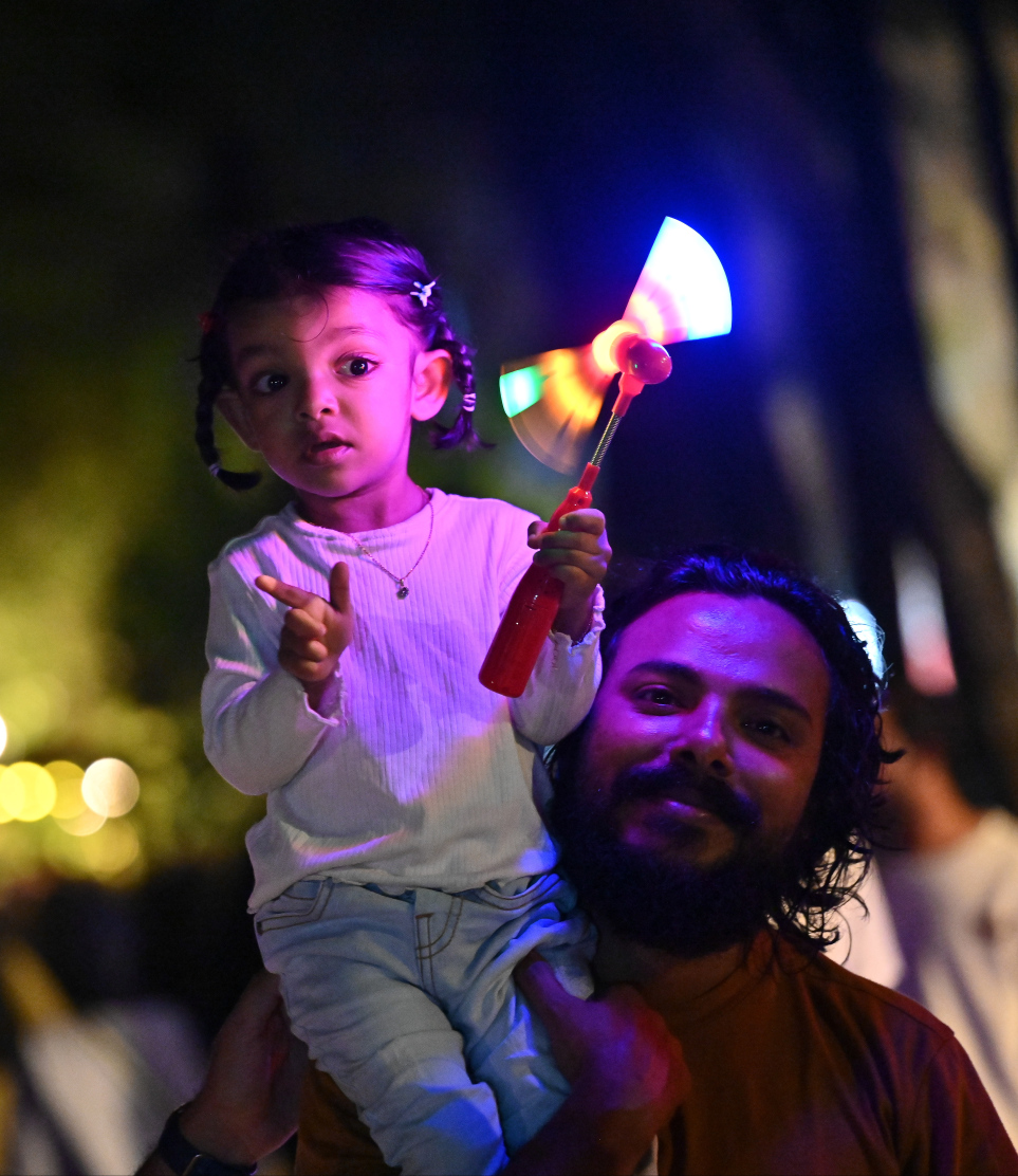 ބޮޑު އީދަށް މަރުހަބާ ކިޔުމަށް ހުޅުމާލޭގައި އީދު މަޅި ރޯކުރުމަށް މިރޭ ބޭއްވި ހަރަކާތް ބަލަން ދިޔަ މީހަކު ކުޑަކުއްޖަކު އުރާލައިގެން.---ފޮޓޯ: ނިޝާން އަލީ| މިހާރު