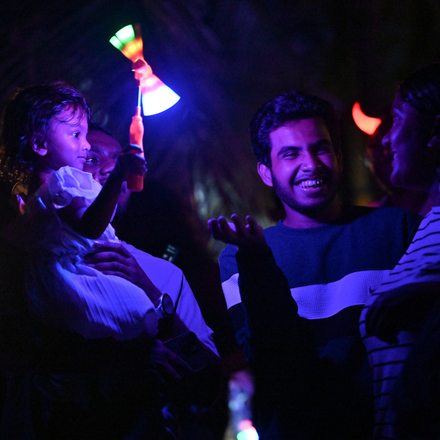 ބޮޑު އީދަށް މަރުހަބާ ކިޔުމަށް ހުޅުމާލޭގައި އީދު މަޅި ރޯކުރުމަށް މިރޭ ބޭއްވި ހަރަކާތް ބަލަން ދިޔަ ބައެއް މީހުން ކުޑަކުއްޖަކު އުރާލައިގެން.---ފޮޓޯ: ނިޝާން އަލީ| މިހާރު