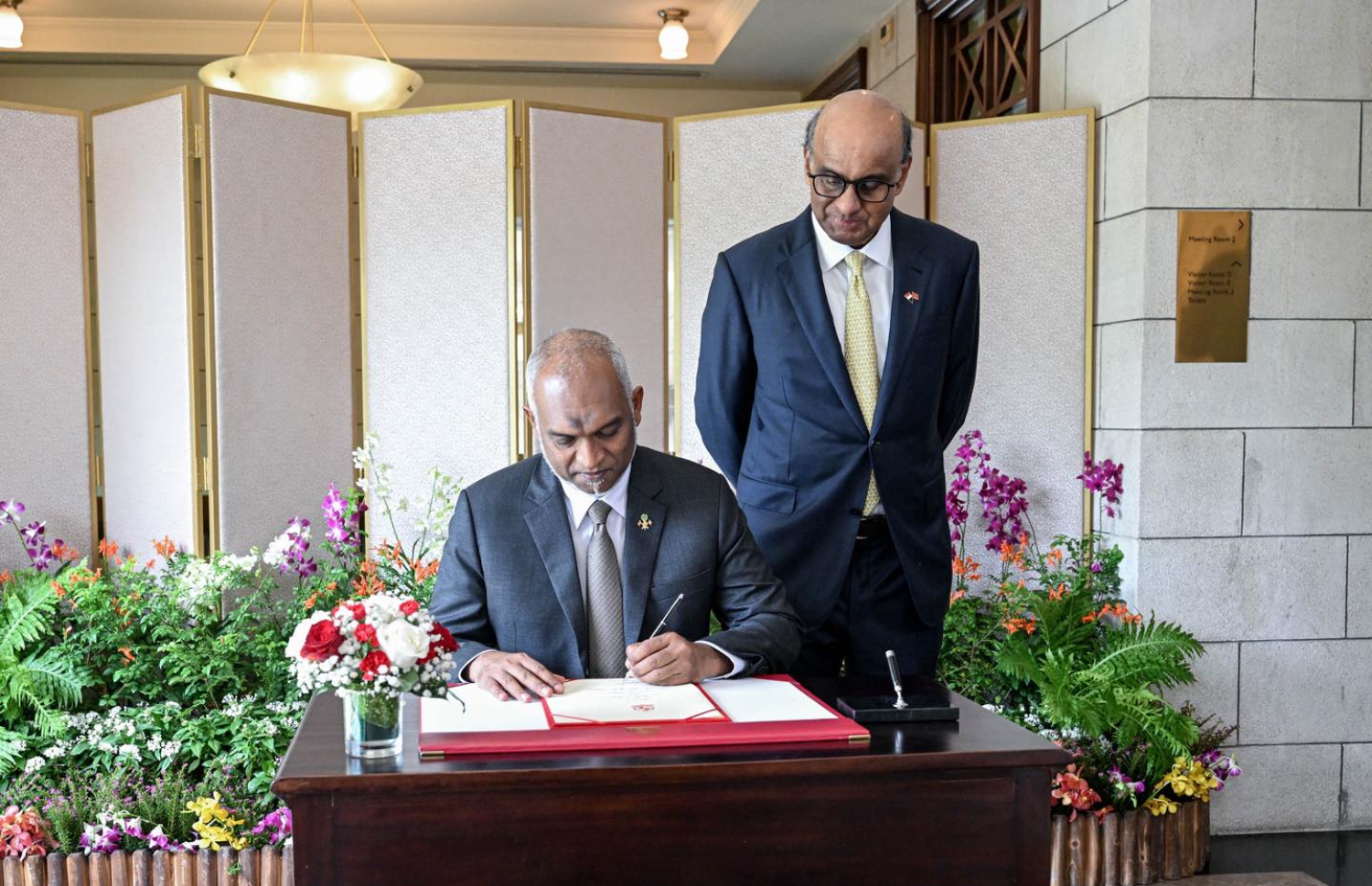 ސިންގަޕޫރުގެ ރައީސް ތަރްމަން ޝަންމުގަރަނަމްގެ ދައުވަތަކަށް ރައީސް މުއިއްޒާއި ފަސްޓް ލޭޑީ ސާޖިދާ މުހައްމަދު އެ ގައުމަށް ކުރައްވަމުން ގެންދަވާ ދަތުރުފުޅުގެ ތެރެއިން ރައީސް މުއިއްޒަށް ރައީސް އެ ގައުމުން ރަސްީކޮށް މަރުހަބާ ދެންނެވުމަށް ބޭއްވި ރަސްމިއްޔާތުގައި އިއްޒަތްތެރިން ސޮއިކުރާ ފޮތުގައި ރައީސް ސޮއި ކުރައްވަނީ.-- ފޮޓޯ: ރައީސް އޮފީސް