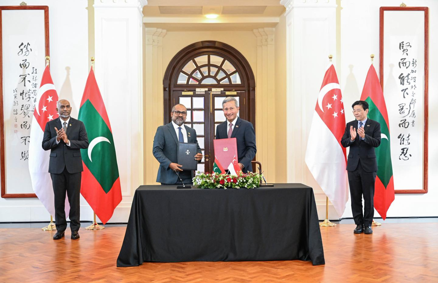 ރައީސް މުއިއްޒު މިހާރު ސިންގަޕޫރަށް ކުރައްވަމުން ގެންދަވާ ފުރަމާނަ ދަތުރުފުޅުގެ ތެރެއިން ދެ ގައުމުގެ ދެމެދުގައި އެމްއޯޔޫއެއްގައި ސޮއިކުރެއްވުމަށް ފަހު ދެ ގައުމުގެ އިސް އޮފިޝަލުން ފޮޓޯއަކަށް ހުއްޓިވަޑައިގެން އަދި ރައީސް މުއިއްޒާއި ސިންގަޕޫރުގެ ބޮޑުވަޒީރު  ބޮޑުވަޒީރު ލޮރެންސް ވޮންގް އެ ރަސްމިއްޔާތުގައި ބައިވެރިވެވަޑައިގަންނަވަނީ--- ފޮޓޯ: ރައީސް އޮފީސް