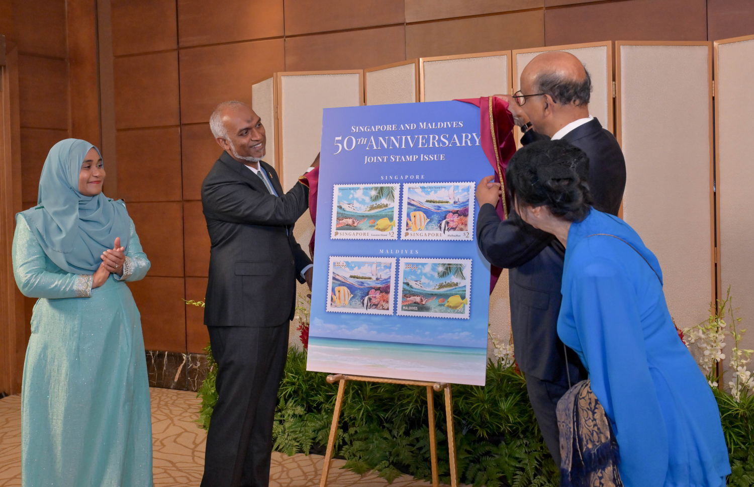 ރައީސް ޑރ މުހައްމަދު މުއިއްޒު ދެކަނބަލުންގެ ޝަރަފުގައި ސިންގަޕޫރުގެ ރައީސް ތަރްމަން ޝަންމުގަރަނަމް ދެއްވި ރަސްމީ ފަރިއްކޮޅުގައި، ރާއްޖެ އާއި ސިންގަޕޫރުގެ 50 އަހަރުގެ ސިޔާސީ ގުޅުން ފާހަގަކުރުމުގެ ގޮތުން، ހަނދާނީ ސްޓޭމްޕެއް ނެރެދެއްވަނީ -- ފޮޓޯ: ރައީސް އޮފީސް