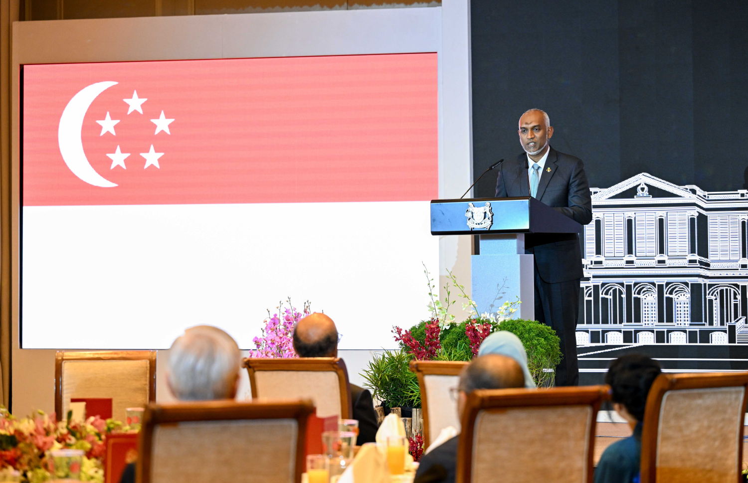 ރައީސް ޑރ. މުހައްމަދު މުއިއްޒުގެ ދެކަނބަލުންގެ ޝަރަފުގައި ސިންގަޕޫރުގެ ރައީސް ތަރްމަން ޝަންމުގަރަނަމް ދެއްވި ރަސްމީ ފަރިއްކޮޅުގައި ރައީސް މުއިއްޒު ވާހަކަފުޅު ދައްކަވަނީ. --- ފޮޓޯ: ރައީސް އޮފީސް