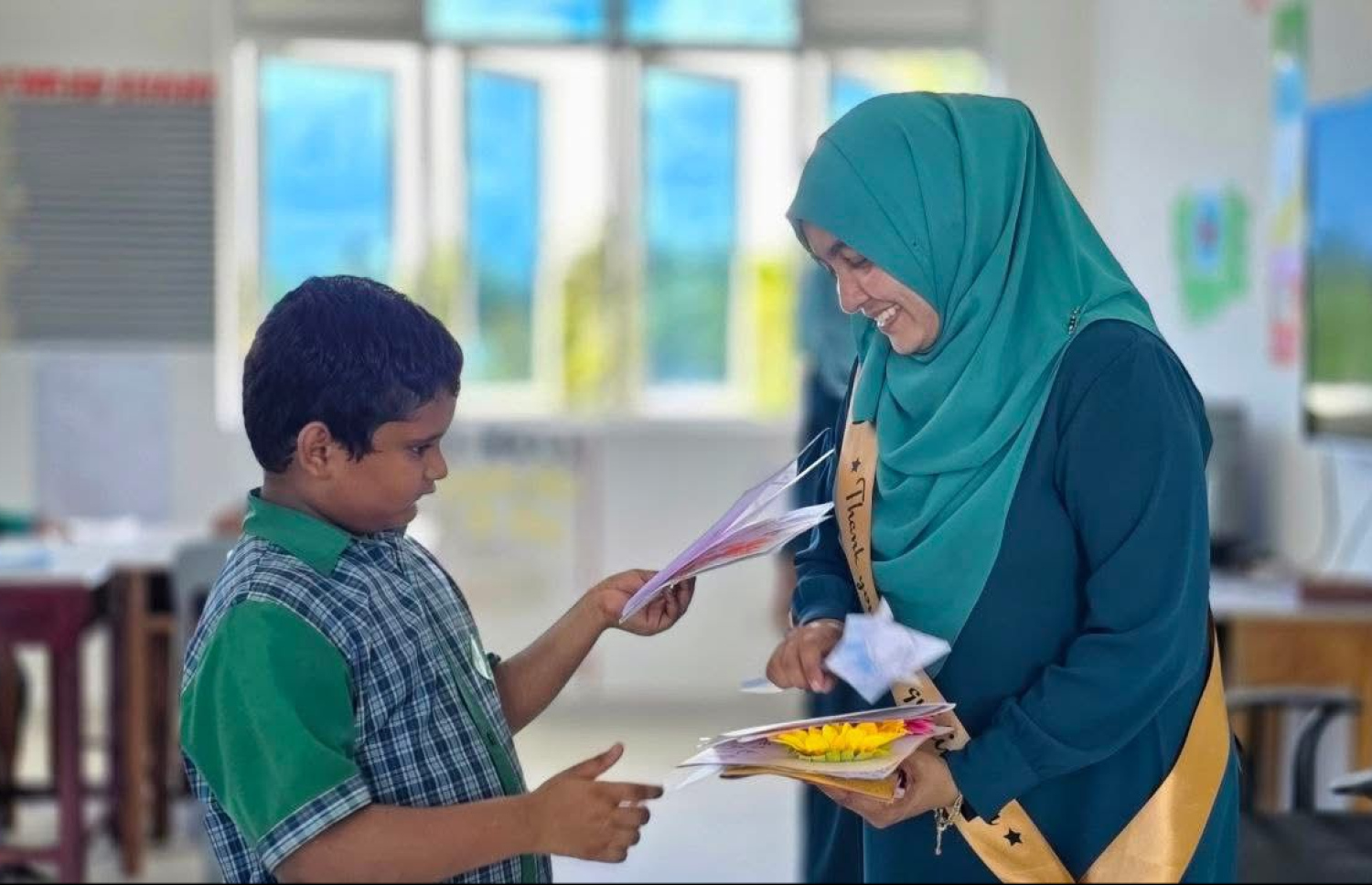 ސ. އަތޮޅު މަދަރުސާގައި 16 އަހަރު މަސައްކަތް ކުރެއްވި ޕްރިންސިޕަލް އައިމިނަތު ޒީނިޔާއަށް އެ ސްކޫލުން ދިން ފެއާވެލްގައި ދަރިވަރުންތަކަކާއެކު.-- ފޮޓޯ: ސ. އަތޮޅު މަދަރުސާ