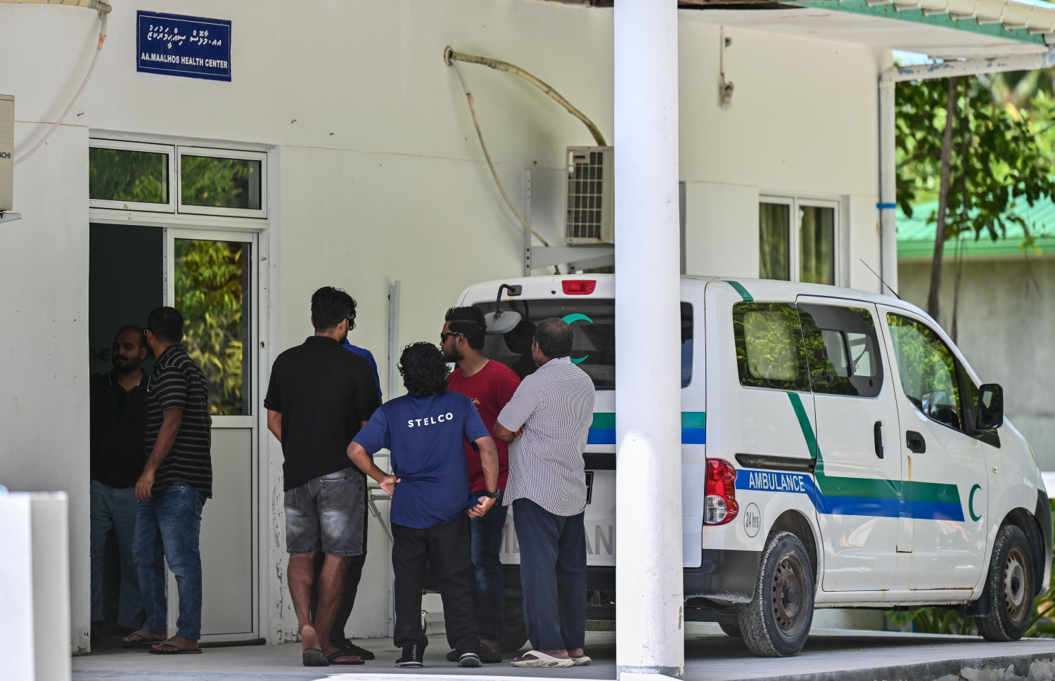 އއ. މާޅޮހުގައި އަބްދުއްރަހަހުމާން އާދަމްގެ ހަށިގަނޑު މި ރަށު ސިއްހީ މަރުކަޒުގައި ބާއްވާފައި އޮތް އިރު، މަރުކަޒު ބޭރުގައި އާއިލާގެ ބައެއް މީހުން ހަރަކާތްތެރިވަނީ--- ފޮޓޯ: ފަޔާޒު މޫސާ | މިހާރު