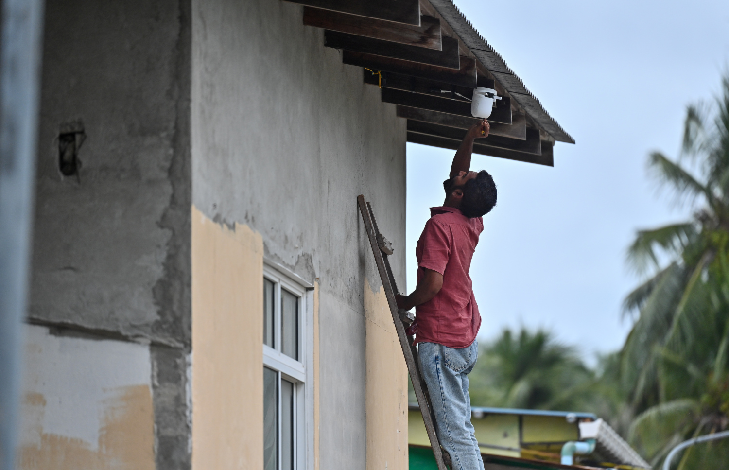 އަބްދުއްރަހުމާން މަރައިލި މައްސަލައިގެ ތަހުގީގަށް މާޅޮހުގެ ގެއެެއްގެ ސީސޓީވީ ކެމެރާ ޗެކް ކުރުމަށް ފުލުހުންގެ ބައެއް ސާމާނު ނަގަނީ.---ފޮޓޯ: ފަޔާޒު މޫސާ| މިހާރު