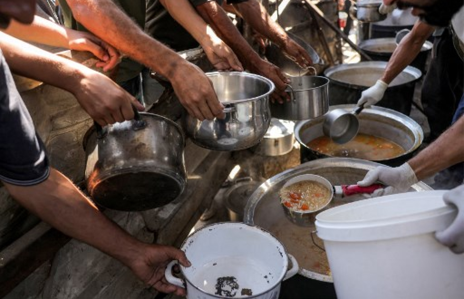 ޣައްޒާގައި ކާނާ ބަހާ ތަނެއްގެ ކައިރީ މީހުން ކާނާ ހޯދަން ކިއޫ ހަދައިގެން: އިޒްރޭލުން ބުނަނީ ޣައްޒާގެ އާންމުންނަށްވާ ވަރަށް ކާނާ ލިބޭ ކަމަށް. -- ފޮޓޯ: އޭއެފްޕީ