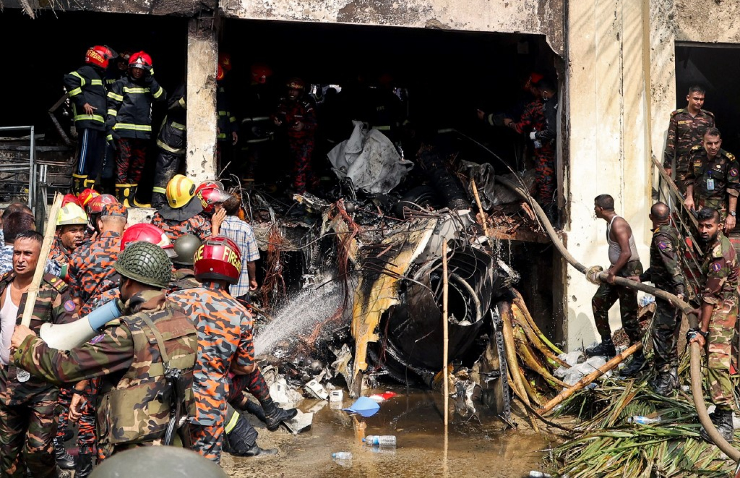 ބަންގްލާދޭޝްގައި މިއަދު ސްކޫލެއްގެ ތެރެއަށް ޖެޓެއް ވެއްޓުނު ހާދިސާއަށް ފަހު ރޯވި އަލިފާން ނިއްވައި މީހުން ހޯދުމުގެ މަސައްކަތްކުރަނީ. -- ފޮޓޯ: އޭއެފްޕީ