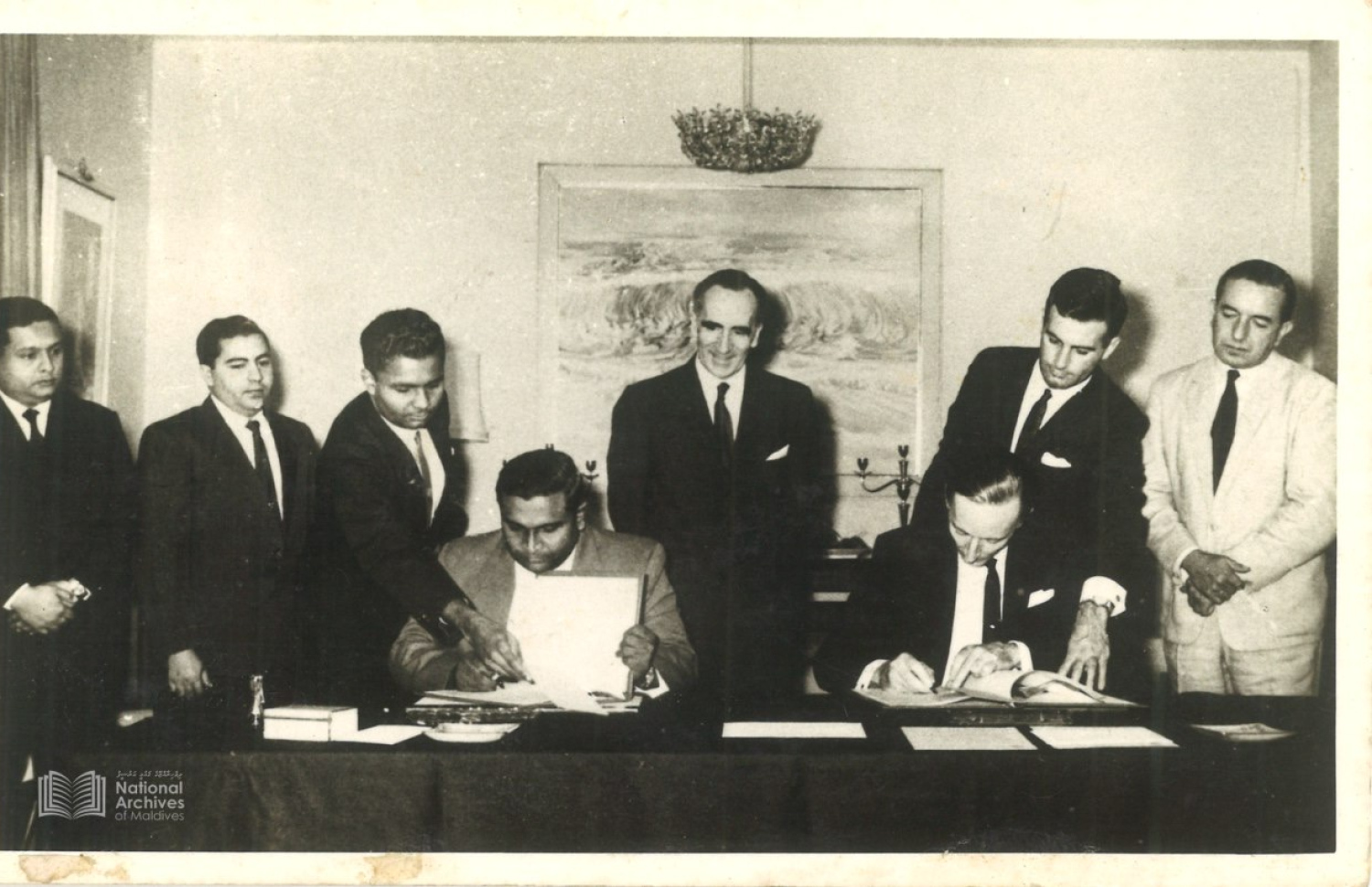 ޖުލައި 26، 1965 ގައި ސްރީ ލަންކާގެ ވެރިރަށް ކޮޅުނބުގައި، ރާއްޖޭގެ ބޮޑުވަޒީރު އިބްރާހީމް ނާސިރު އާއި އިނގިރޭސި ހައިކޮމިޝަނަރު މައިކަލް ވޯކާ، ރާއްޖޭގެ މިނިވަންކަމުގެ އެއްބަސްވުމުގައި ސޮއިކުރައްވަނީ. – ފޮޓޯ: ދިވެހިރާއްޖޭގެ ގައުމީ އަރުޝީފް