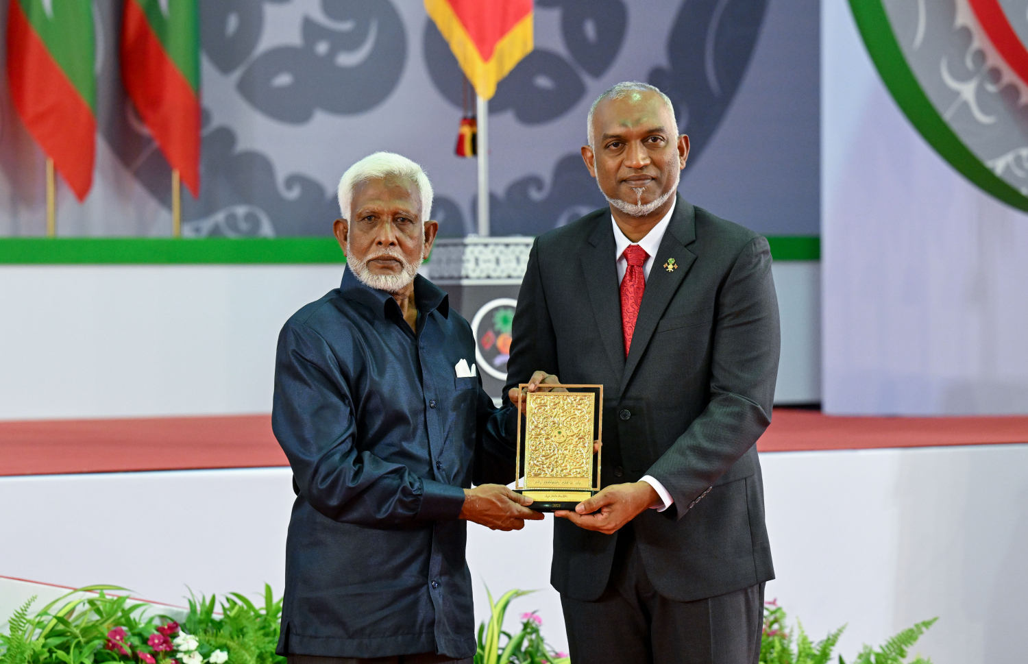 ދިވެހި ދައުލަތަށް ދިގު މުއްދަތަކަށް ހިދުމަތް ކުރެއްވި ބޭފުޅެއްގެ ހިދުމަތުގެ އަގު ވަޒަން ކުރައްވައި، ރައީސް މުއިއްޒު ޝަރަފުގެ ބެޖާއި އައްޑަނަ ދެއްވަނީ.--- ފޮޓޯ: ރައީސް އޮފީސް