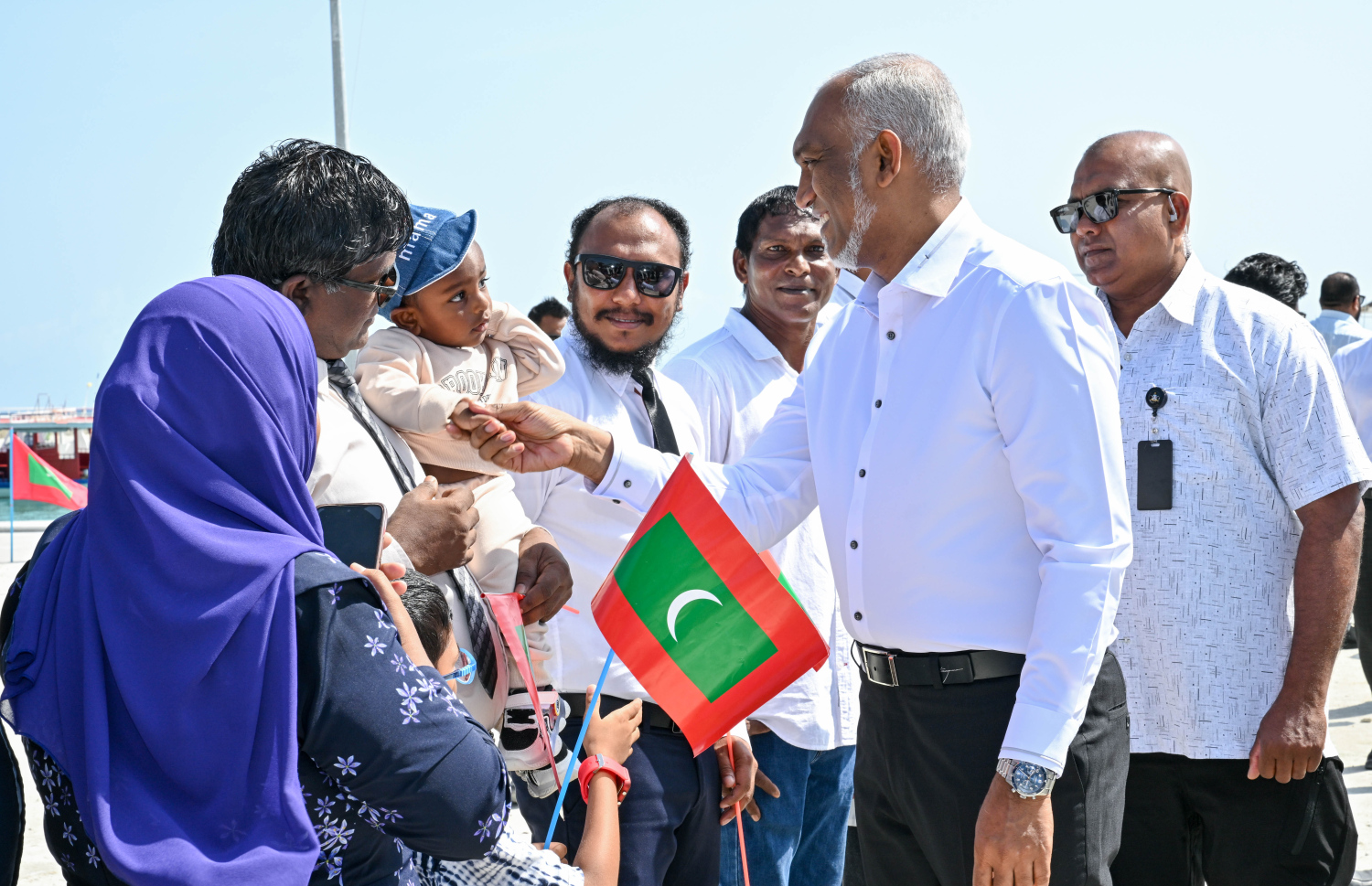 ރައިސް ޑރ. މުހައްމަދު މުއިއްޒު ބ. ކަމަދޫއަށް ވަޑައިގަތުމުން އެ ރަށުން އެމަނިކުފާނަށް މަރުހަބާ ކިޔުމަށް ނިކުތް ކުޑަކުއްޖަކާ ސަލާމް ކުރައްވަނީ،.--- ފޮޓޯ: ރައީސް އޮފީސް