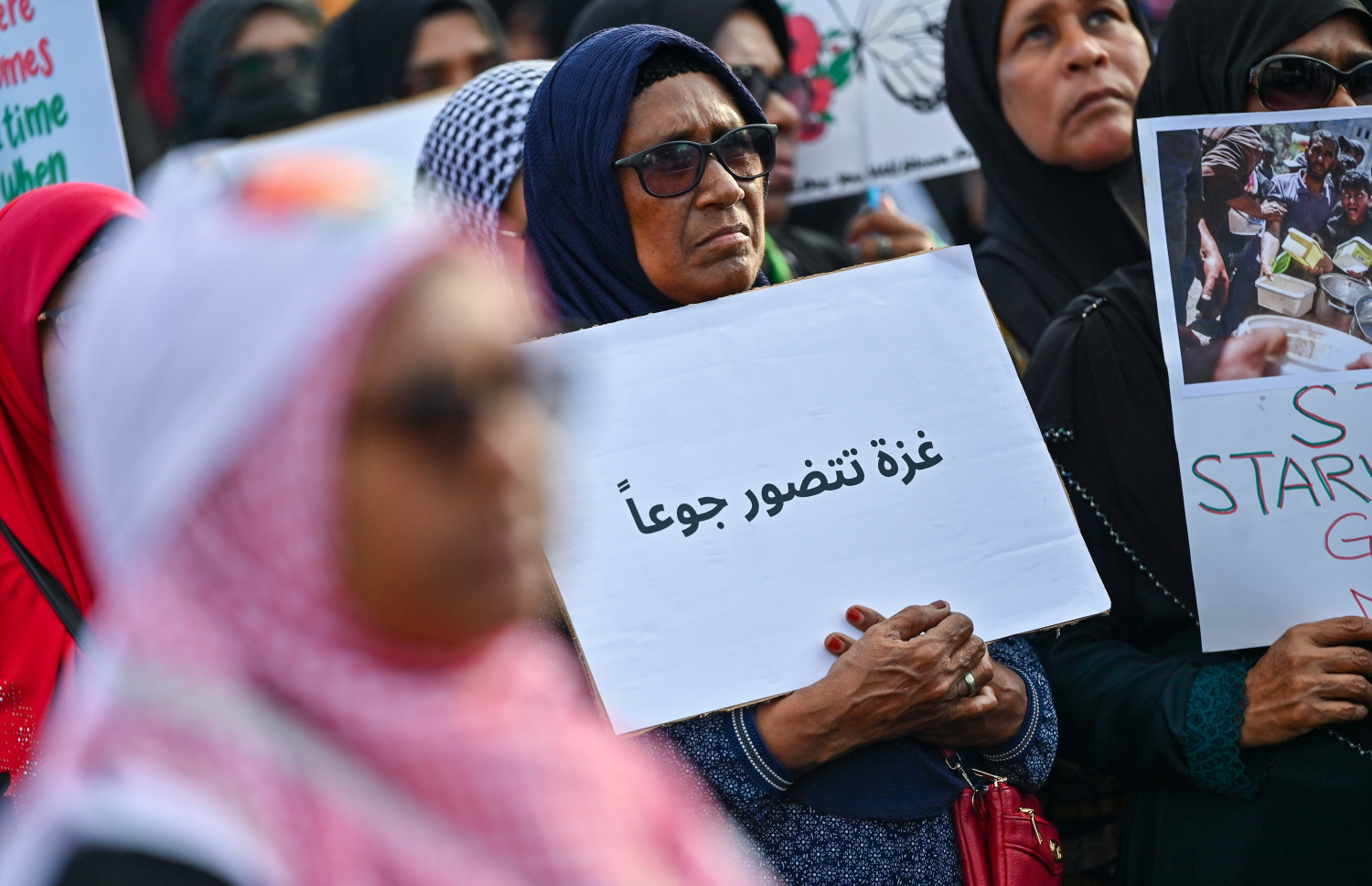 އިޒްރޭލުގެ ޖަރީމާތަކާ ދެކޮޅަށް މާލޭގައި ބޭއްވި ބޮޑު އެއްވުމުގެ ބައިވެރިން ޕޯސްޓަރުތައް ހިފައިގެން. މި އެއްވުމުގައި އެތައް ހާސް ބަޔަކު ބައިވެރިވި.--- ފޮޓޯ: ފަޔާޒު މޫސާ | މިހާރު