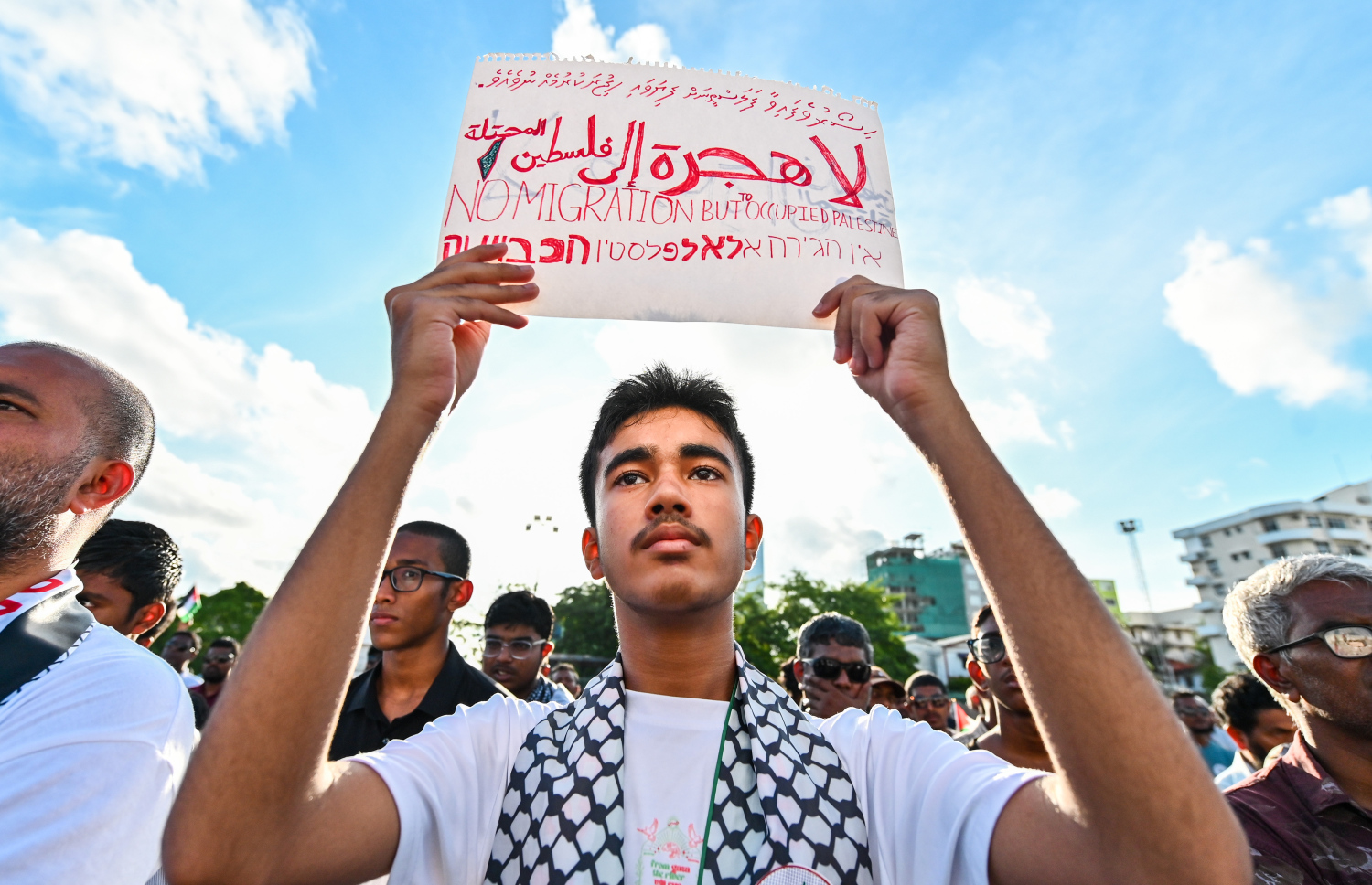 އިޒްރޭލުގެ ޖަރީމާތަކާ ދެކޮޅަށް ބޭއްވި ބޮޑު އެއްވުމުގައި ދިވެހި، އިނގިރޭސި، އަރަބި އަދި ހިބްރޫ ބަހުން ލިޔެފައިވާ ޕޯސްޓަރެއް ހިފައިގެން މީހަކު ބައިވެރިވަނީ.--- ފޮޓޯ: ފަޔާޒު މޫސާ | މިހާރު