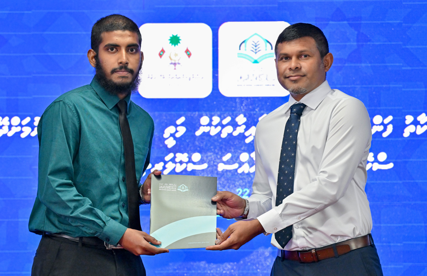 ޒަކާތު ފަންޑުން ދޭ ސްކޮލަޝިޕް ލިބުނު މީހަކަށް ނައިބު ރައީސް ހުސެއިން މުހައްމަދު ލަތީފް ލިޔުން ހަވާލުކޮށްދެއްވަނީ.-- ފޮޓޯ: ރައީސް އޮފީސް