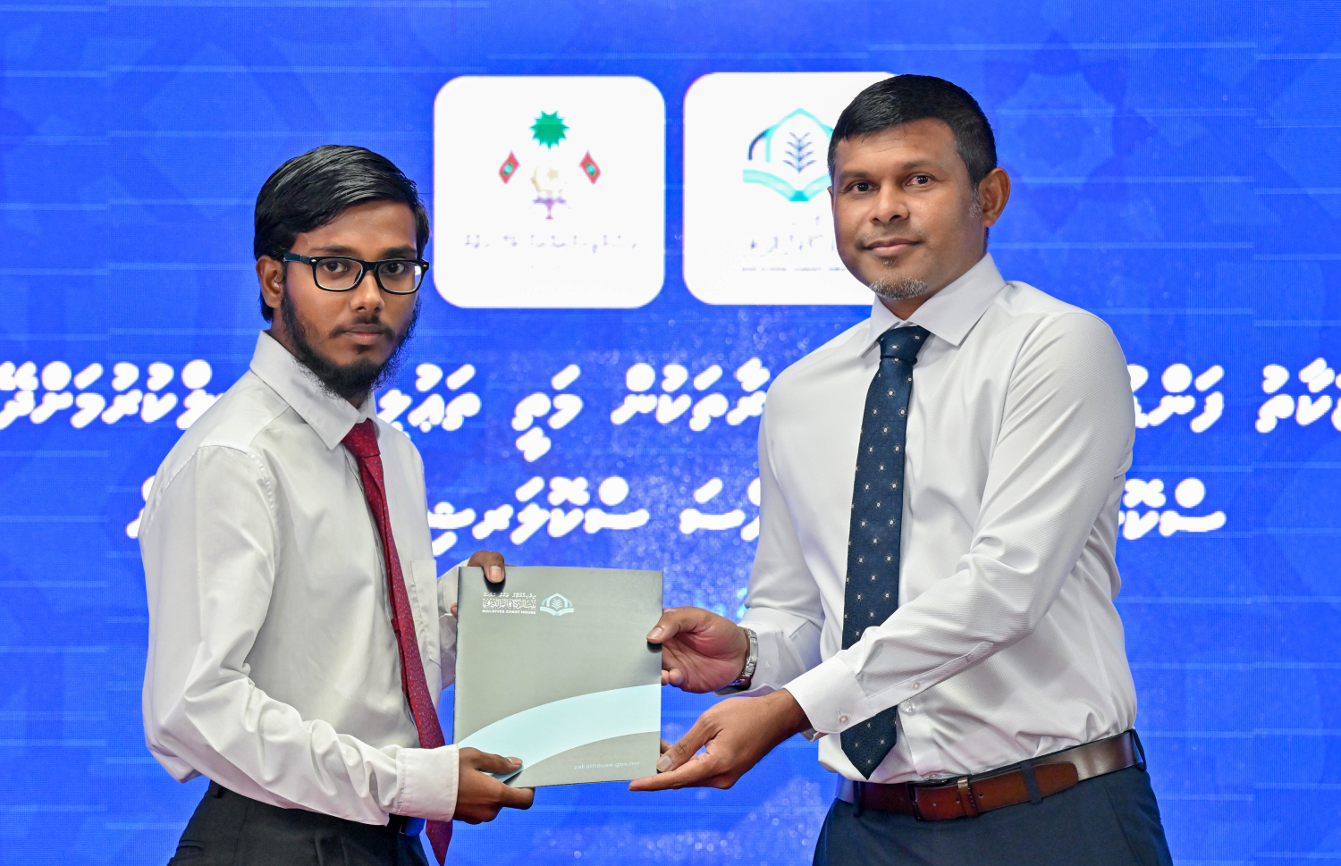 ޒަކާތު ފަންޑުން ދޭ ސްކޮލަޝިޕް ލިބުނު މީހަކަށް ނައިބު ރައީސް ހުސެއިން މުހައްމަދު ލަތީފް ލިޔުން ހަވާލުކޮށްދެއްވަނީ.-- ފޮޓޯ: ރައީސް އޮފީސް