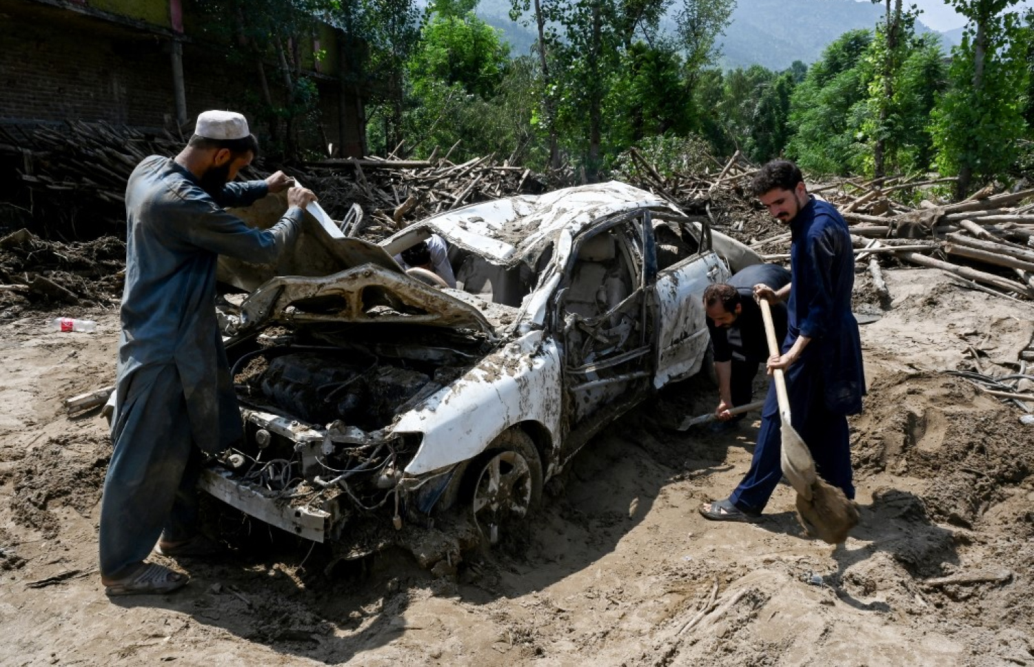 ޕާކިސްތާނުގައި ފެންބޮޑުވި އަވަށެއްގައި ހަލާކުވެފައިވާ ކާރެއްގެ  އެތެރެ ބަލަން ބަޔަކު މަޑުކޮށްލައިގެން. -- ފޮޓޯ: އޭއެފްޕީ