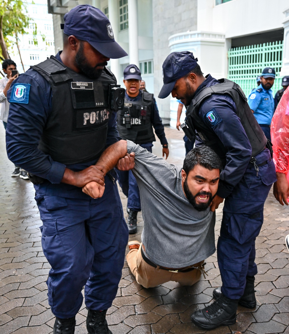 ރައީސް އޮފީސް ކުރިމަތީގައި ނޫސްވެރިން އިހުތިޖާޖުކުރަނިކޮށް ފުލުހުން ބާރުގެ ބޭނުންކޮށްގެން ނޫސްވެރިޔާ މުހައްމަދު ޝަހްޒާން އެ ސަރަހައްދުން ދުރަށް ގެންދަނީ.-- ފޮޓޯ: ފަޔާޒް މޫސާ | މިހާރު