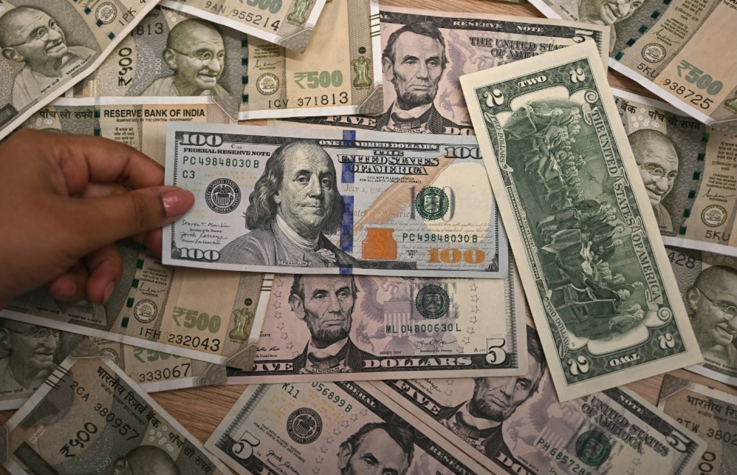 އިންޑިއާގައި ބޭރު ފައިސާ މާރުކުރާ ތަނެއްގައި މުވައްޒަފަކު ރުޕީސް އާއި އެމެރިކާ ޑޮލަރުތަކެއް ގެންގުޅެނީ. --ފޮޓޯ: އޭއެފްޕީ