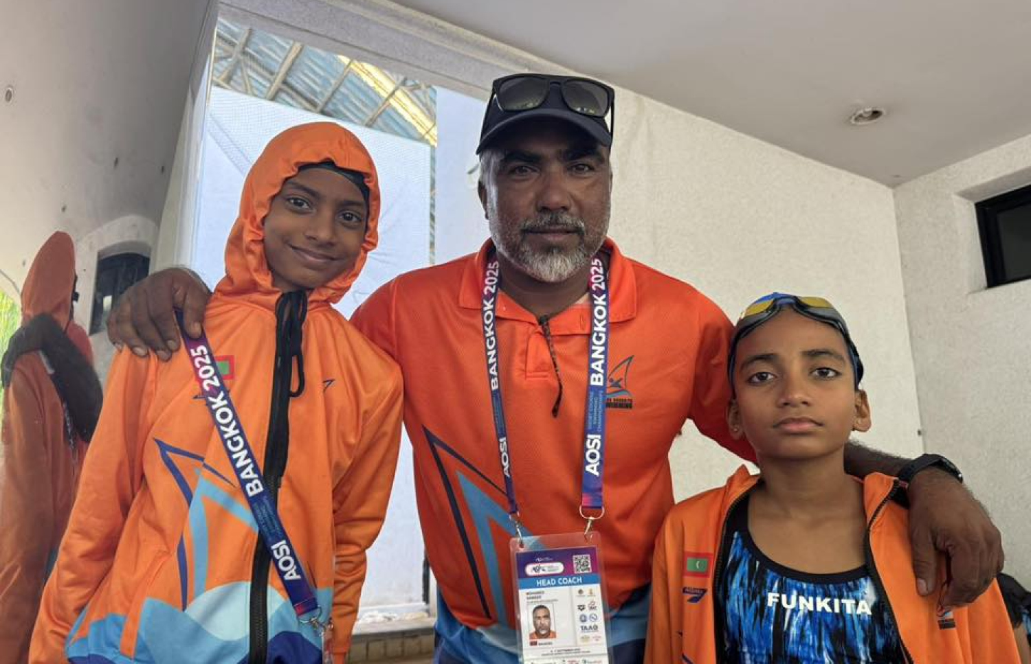 ތައިލެންޑުގެ ބެންކޮކްގައި ބޭއްވި އޭޝިއަން އޯޕަން ސްކޫލް އިންވިޓޭޝަނަލް ޝޯޓްކޯސް މުބާރާތުގައި ބައިވެރިވި ރާއްޖޭގެ ކްލަބް ބޮޑު ރިޔާގެ ކޯޗު ސަމީރު (މ) ގައި އެ ކްލަބުގެ ދެ ފެތުންތެރިއަކާ އެކު ފޮޓޯއެއް ނަގަނީ.