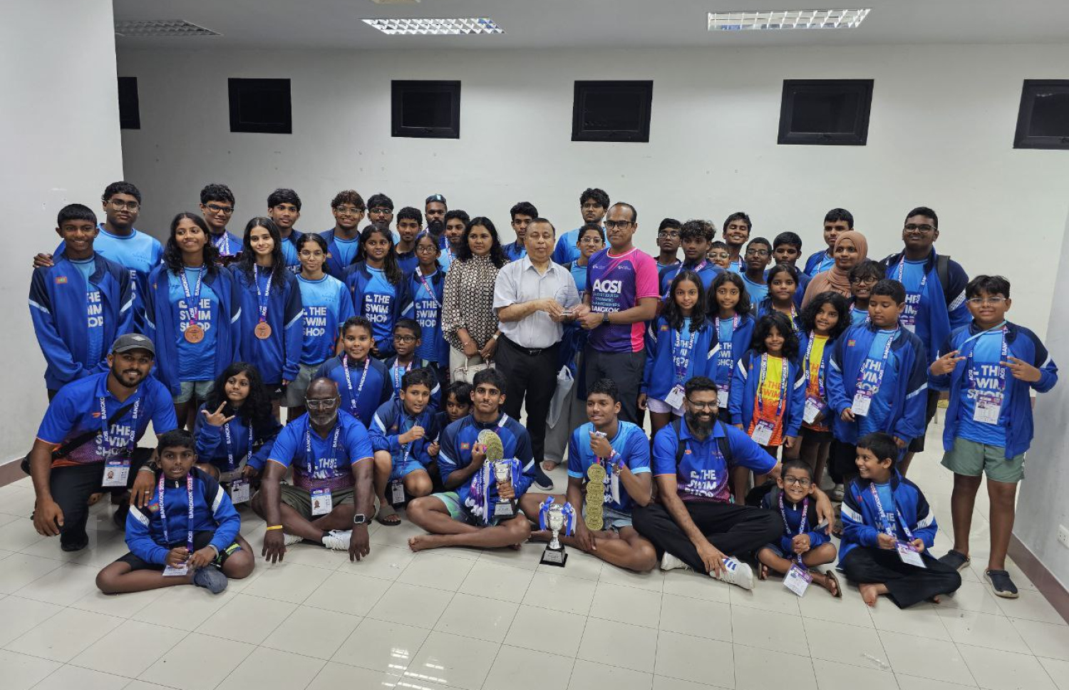 ތައިލެންޑުގެ ބެންކޮކްގައި ބޭއްވި އޭޝިއަން އޯޕަން ސްކޫލް އިންވިޓޭޝަނަލް ޝޯޓްކޯސް މުބާރާތުގައި ބައިވެރިވި ރާއްޖޭގެ ނިއު ލެގޫން ސުވިމިން ކްލަބުގެ ފެތުންތެރިންނާ އެކު، ތައިލެންޑުގައި ހުންނަވާ ދިވެހި ސަފީރުގެ ފުއާދުގެ ދެކަނބަލުން އަދި މުބާރާތުގެ ކޯޑިނޭޓަރު ޝާން ގުރޫޕް ފޮޓޯއެއް ނަންގަވަނީ.