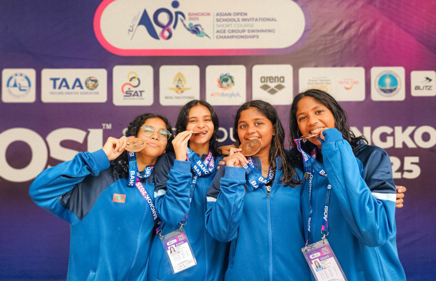 ތައިލެންޑުގެ ވެރިރަށް ބެންކޮކްގައި ބޭއްވި އޭޝިއަން އޯޕަން ސްކޫލް އިންވިޓޭޝަނަލް ޝޯޓްކޯސް މުބާރާތުގައި ރާއްޖޭގެ ނިއު ލެގޫން ސުވިމިން ކްލަބުގެ ފްރީ ސްޓައިލް ރިލޭގެ ބައިވެރިން މެޑަލްއާ އެކު ފޮޓޯއެއް ނަގަނީ.