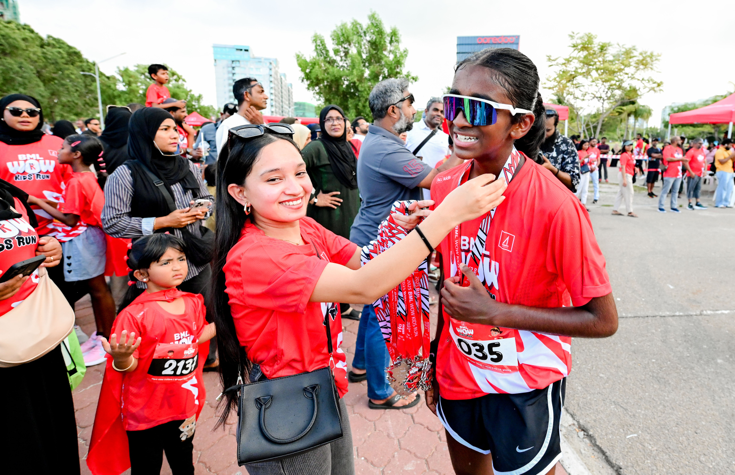 ބީއެމްއެލް އާއި ޓޯޓަލް ފިޓްނަސް ގްރޫޕް (ޓީއެފްޖީ) ގުޅިގެން މިއަދު ހުޅުމާލޭގައި ބޭއްވި ބީއެމްއެލް ވާއު ކިޑްސް ރަންގައި ބައިވެރިވި ދުވުންތެރިއެއްގެ ކަރުގައި މެޑަލް އަޅުވަނީ.-- ފޮޓޯ: ނިޝާން އަލީ | މިހާރު