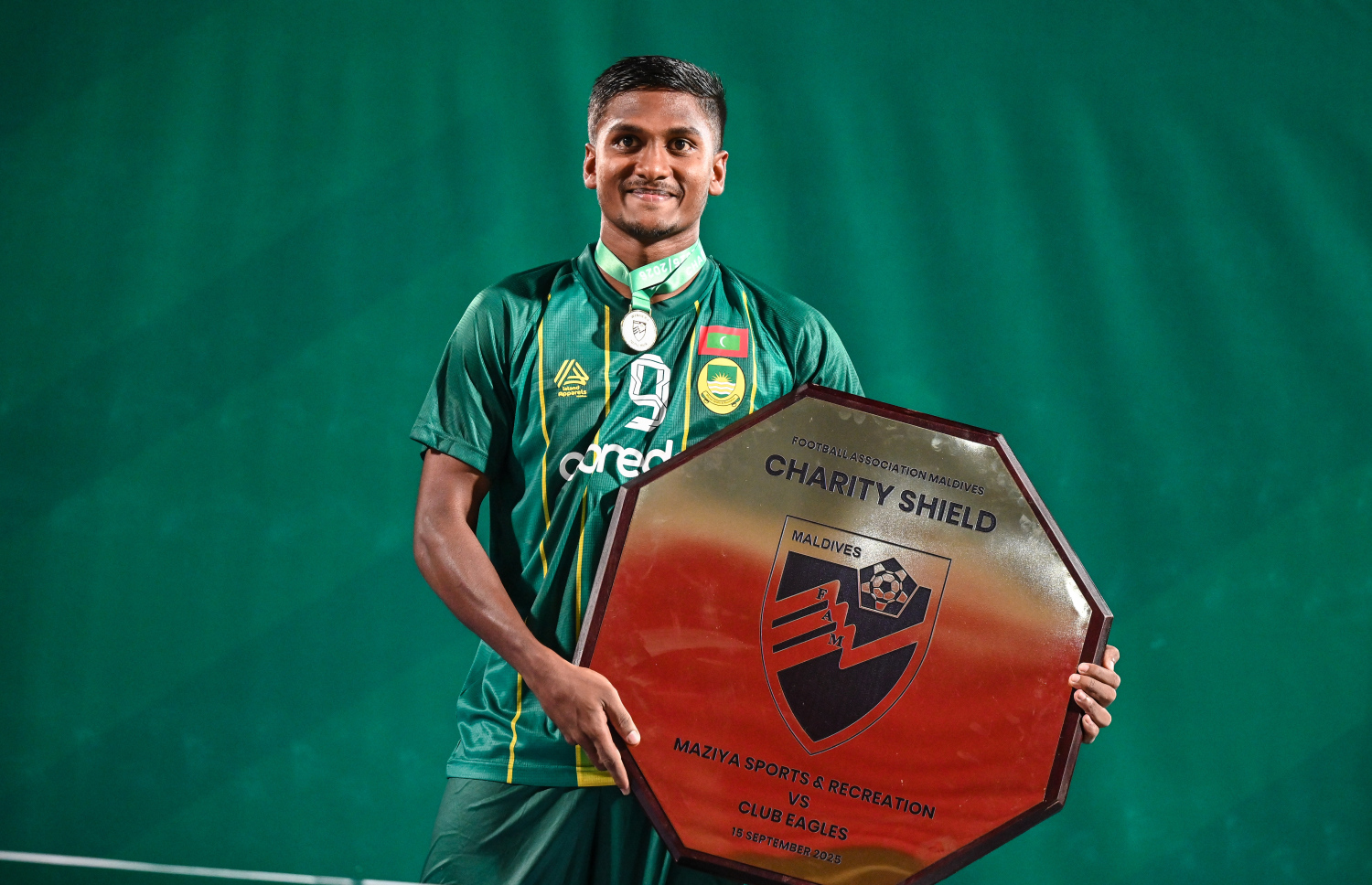 އީގަލްސް ބަލިކޮށް އެފްއޭއެމް ޗެރިޓީ ޝީލްޑް ކާމިޔާބު ކުރުމަށް ފަހު، މާޒިޔާގެ ނާއިޒު ހަސަން (ދާދު) ޝީލްޑާ އެކު، ފޮޓޯއަކަށް ހުއްޓިގެން.--- ފޮޓޯ: ފަޔާޒު މޫސާ | މިހާރު