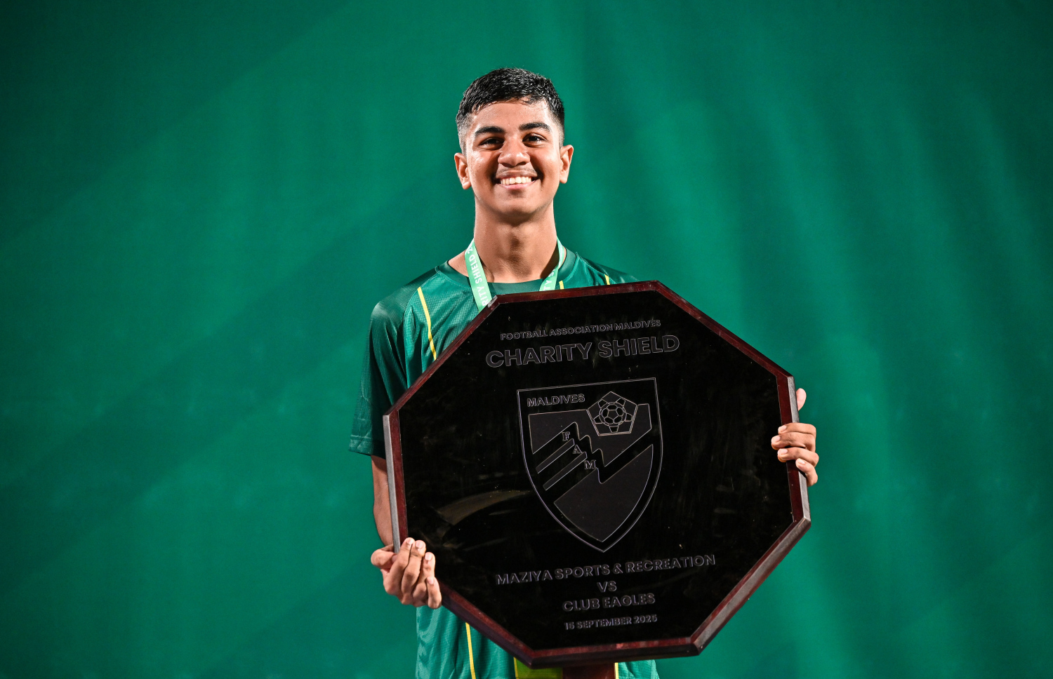 އެފްއޭއެމް ޗެރިޓީ ޝީލްޑް ކާމިޔާބު ކުރުމަށް ފަހު، ޒުވާން ކުޅުންތެރިޔާ މުހައްމަދު އިލާން އިމްރާން ޝީލްޑާ އެކު، ފޮޓޯއަކަށް ހުއްޓިގެން.--- ފޮޓޯ: ފަޔާޒު މޫސާ | މިހާރު