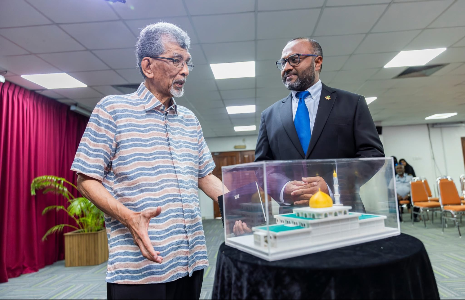 އިސްލާމީ މަރުކަޒު ޑިޒައިންކުރި އާކިޓެކްޓް ހާޖީދާރު އަބްދުލްމާޖިދަށް އިސްލާމިކް މިނިސްޓަރު ޑރ. މުހައްމަދު ޝަހީމް އަލީ ސައީދު އިސްލާމީ މަރުކަޒުގެ ނަމޫނާއެއް ހަދިޔާކުރައްވަނީ. -- ފޮޓޯ: އިސްލާމިކް މިނިސްޓްރީ