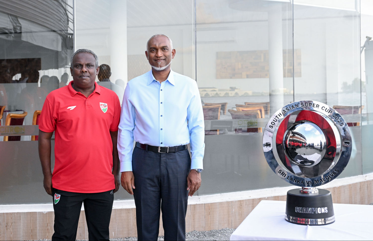 ގައުމީ ފުޓުބޯޅަ ޓީމާ އެކު، ސިޓްރޯން ރެސްޓޯރަންޓްގައި ބޭއްވި ސައިފޮދުގައި ރައީސް މުއިއްޒާއި އެ ޓީމުގެ ކޯޗު މުހައްމަދު ޝިޔާޒު (މޯހަން) ފޮޓޯއަކަށް ތައްޔާރުވެގެން.--- ފޮޓޯ: ރައީސް އޮފީސް