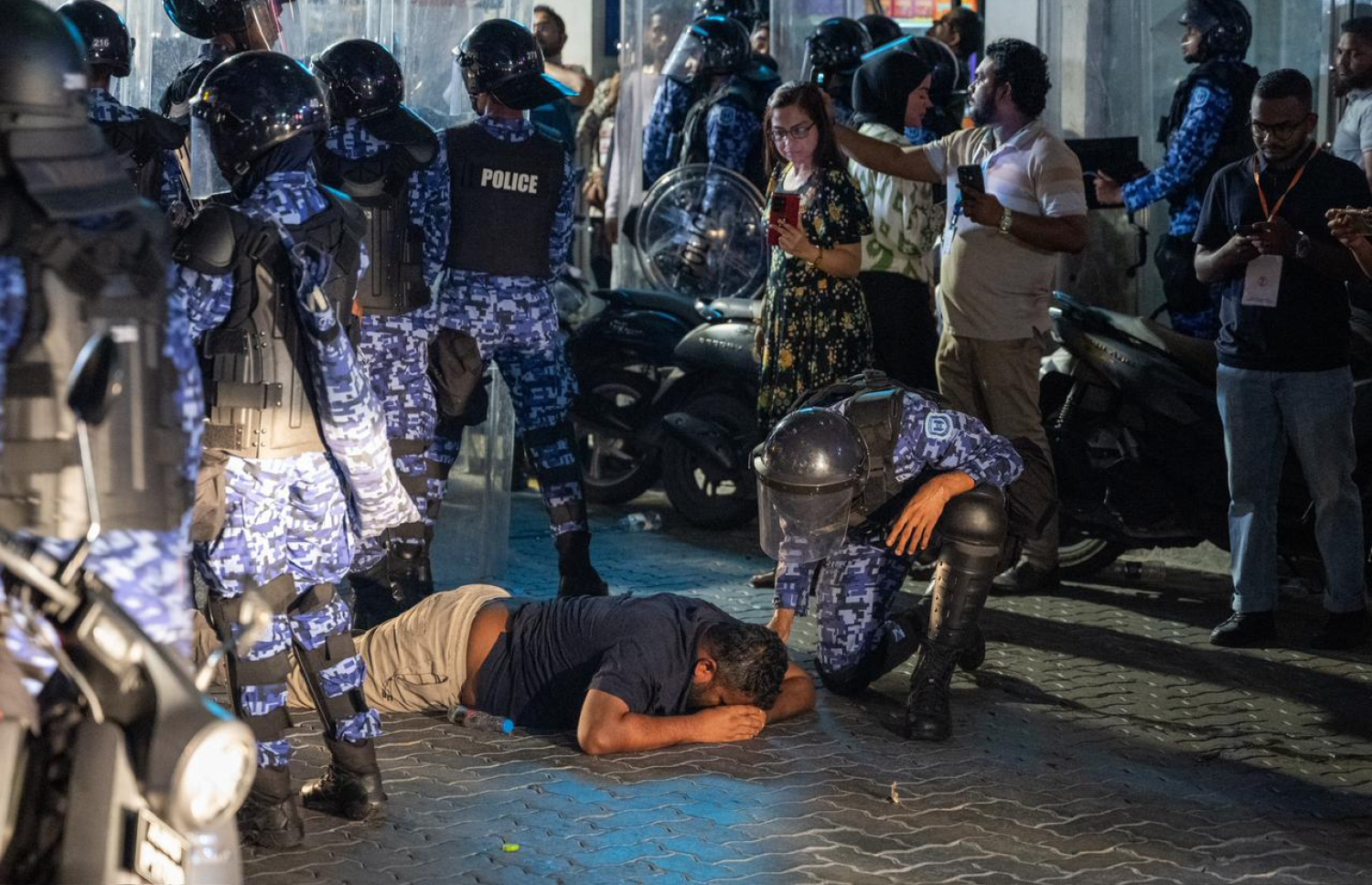 މުޒާހަރާގެ ތެރެއިން މީހަކު ވެއްޓިފައި އޮއްވާ ފުލުހުންތަކެއް މަޑުކޮށްލައިގެން.---ފޮޓޯ: ނިޝާން އަލީ| މިހާރު