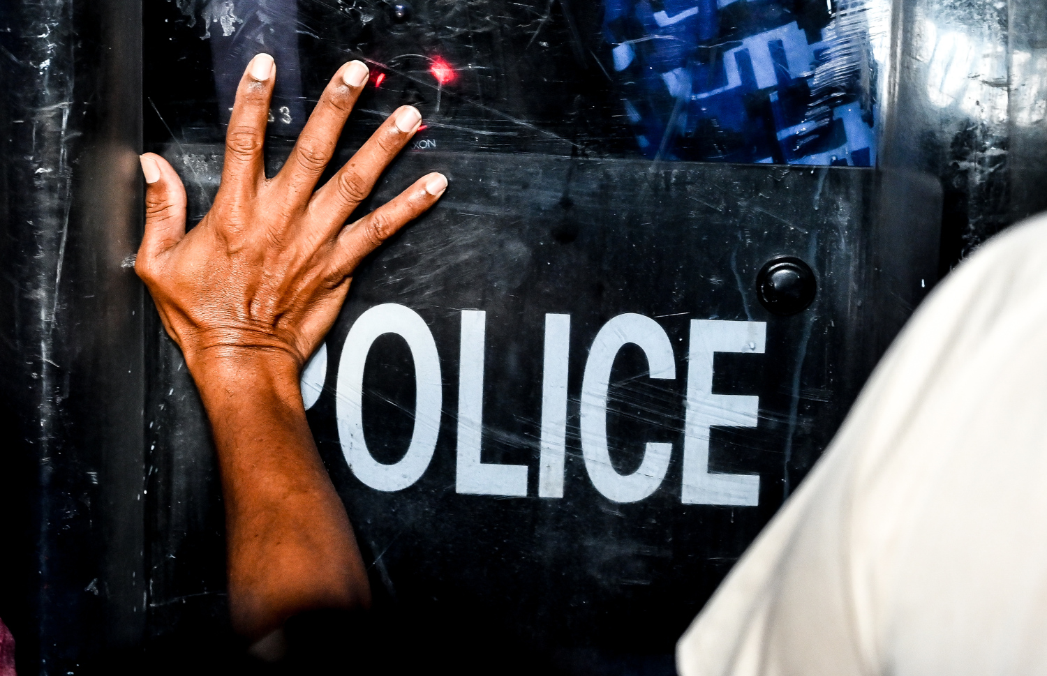 އިދިކޮޅު އެމްޑީޕީން ބޭއްވި އެއްވުމުގެ ބައިވެރިއަކު ފުލުހުންގެ ޝީލްޑުގައި އަތްއަޅައި ކޮއްޕަނީ.--- ފޮޓޯ: ފަޔާޒު މޫސާ | މިހާރު