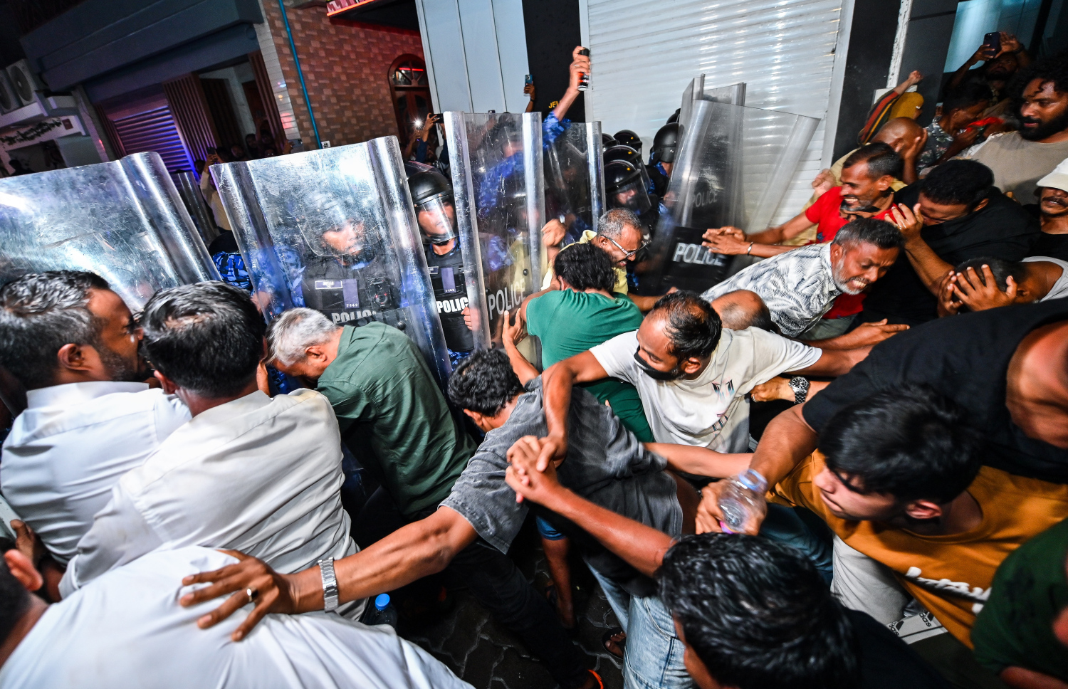 އެމްޑީޕީގެ އެއްވުމުގެ ބައިވެރިން ފުލުހުންގެ އެންގުމާ ހިލާފަށް މަޖީދީ މަގަށް ވަނުމަށްޓަކައި ފުލުހުންގެ ސަފު ފޫއަޅުވައިލަން އުޅުމުން ފުލުހުންނާ ދެމެދު ހަމަނުޖެހުން ހިނގަނީ: އެ މީހުން ފަހަތަށް ޖައްސަން ފުލުހުން ޕެޕާސްޕްރޭ ވެސް ބޭނުންކުރި.---ފޮޓޯ: ފަޔާޒު މޫސާ| މިހާރު