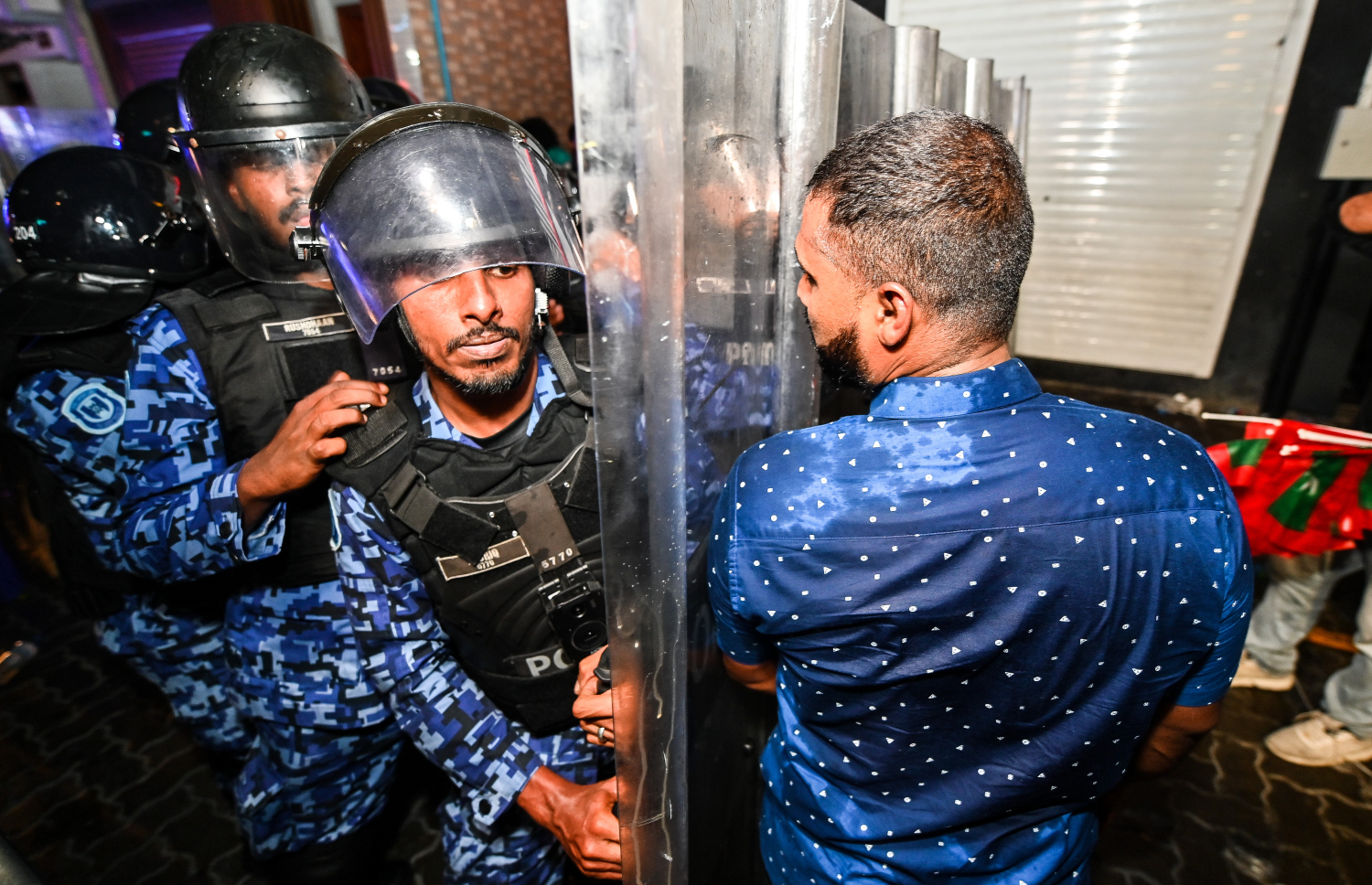 "ލޫޓުވައިފި ލޫޓޫވައިފި" ނަމުގައި އިދިކޮޅު އެމްޑީޕީން ބޭއްވި އެއްވުމުގެ ބައިވެރިއަކު ފުލުހުންގެ އެންގުމާ ހިލާފަށް މަޖީދީ މަގުން ކުރިއަށް ދާން މަސައްކަތް ކުރާއިރު، ފުލުހުން ޝީލްޑް ބޭނުންކޮށްގެން އޭނާ ހުއްޓުވަނީ.--- ފޮޓޯ: ފަޔާޒު މޫސާ | މިހާރު