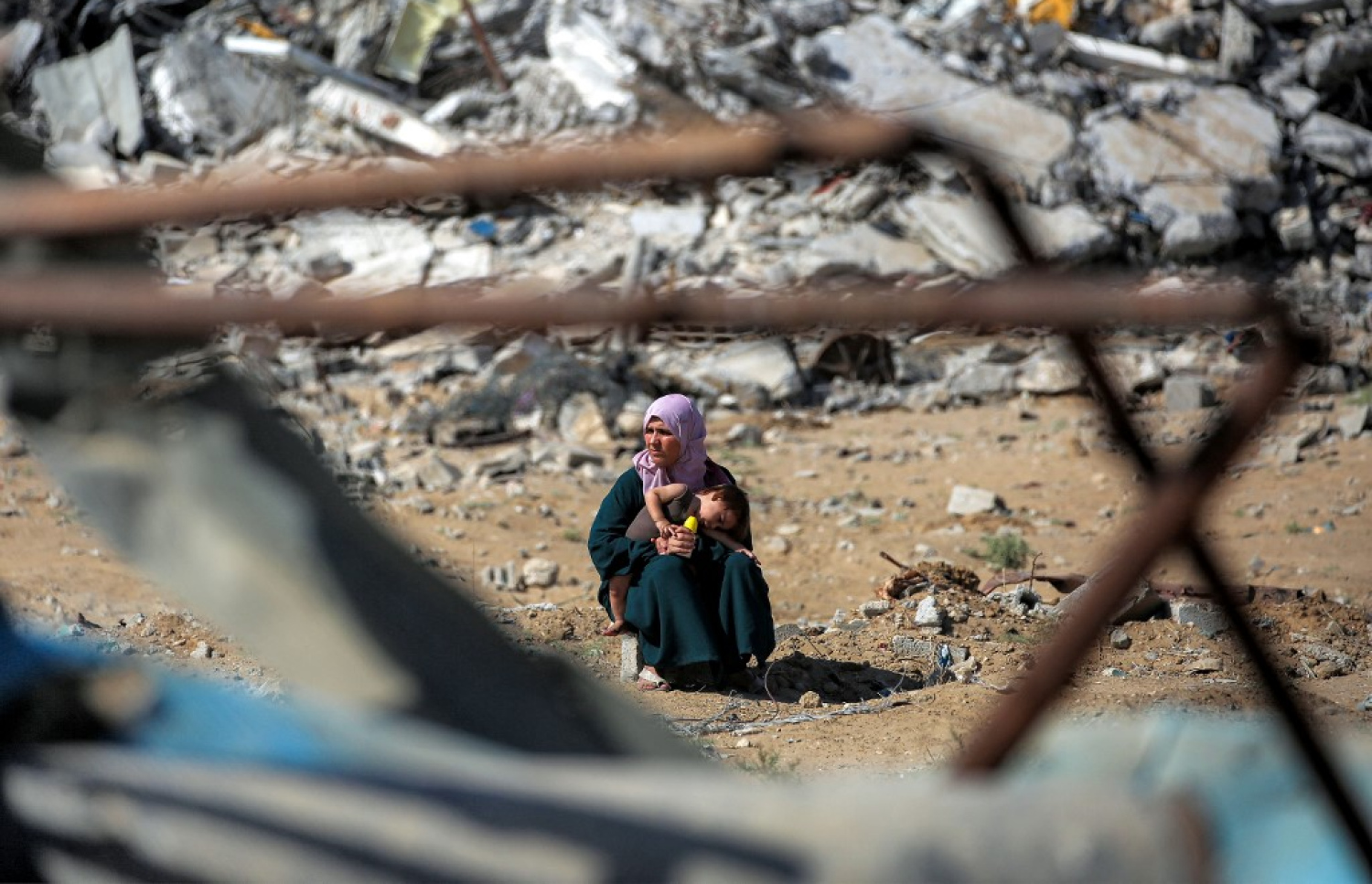 ފަލަސްތީނުގެ ޣައްޒާގައި މީގެ ދެ އަހަރު ކުރިން އިޒްރޭލުން ދޭން ފެށި ހަމަލާތައް މެދުކަނޑާލައި ސިފައިންގެ ފައުޖުތައް ފަހަތަށް ޖެހުމާ އެކު އެނބުރި ވަޒަނަށް ދިޔަ އަންހެނަކު، ވީރާނާ ވެފައިވާ ޣައްޒާގެ މަގެއްގައި ތުއްތު ކުއްޖަކާ އެކު އިށީނދެލައިގެން. -- ފޮޓޯ: އޭއެފްޕީ