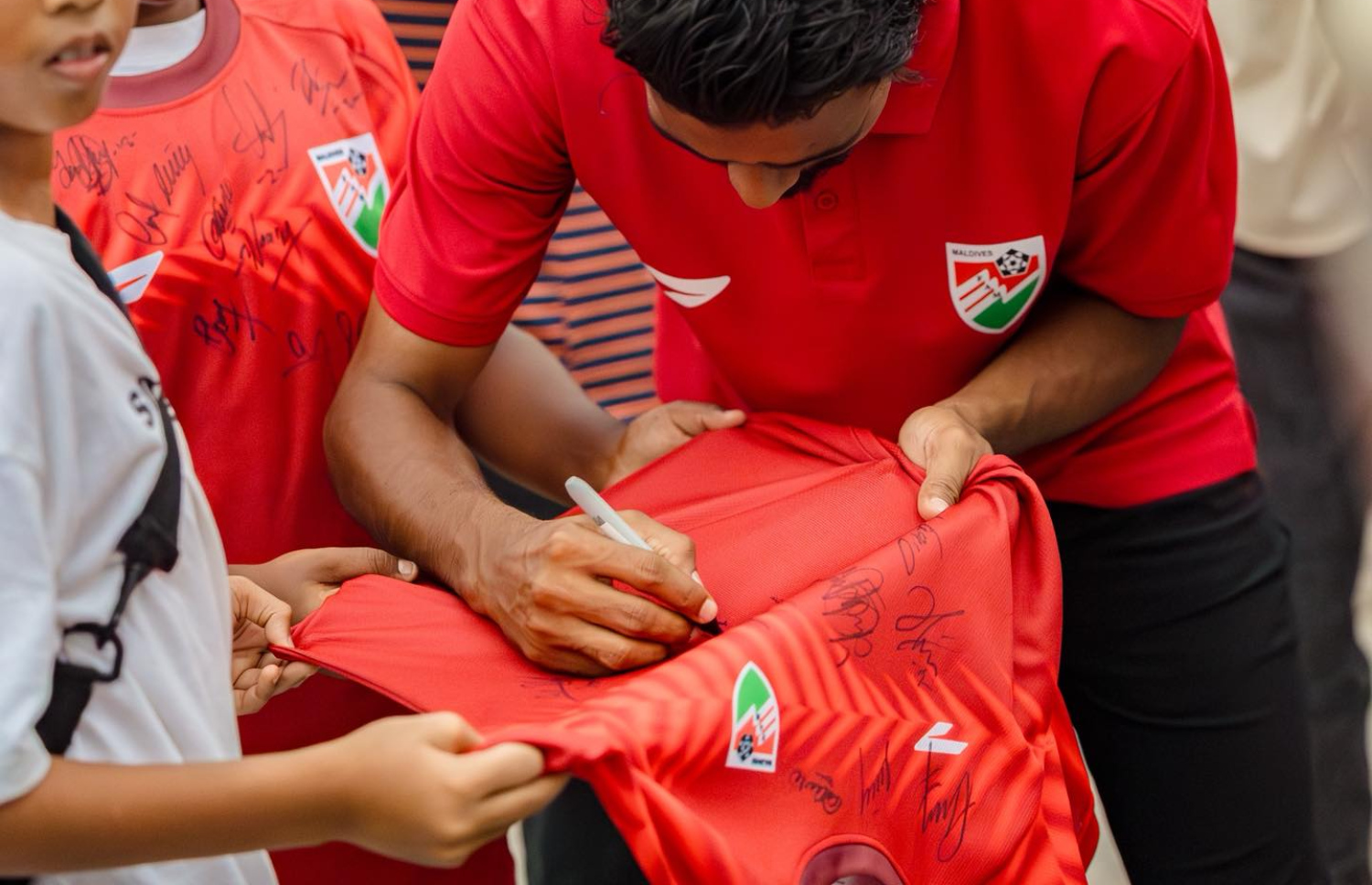 ގައުމީ ޓީމުގެ ކުޅުންތެރިން އޮޓޯގްރާފް ދިނުން ކުރިއަށް ދިޔަ އިވެންޓުގައި މިޑްފީލްޑަރު ނިހާޓް ކުޑަކުއްޖަކަށް އޮޓޯގްރާފް ދެނީ.-- ފޮޓޯ: އެފްއޭއެމް