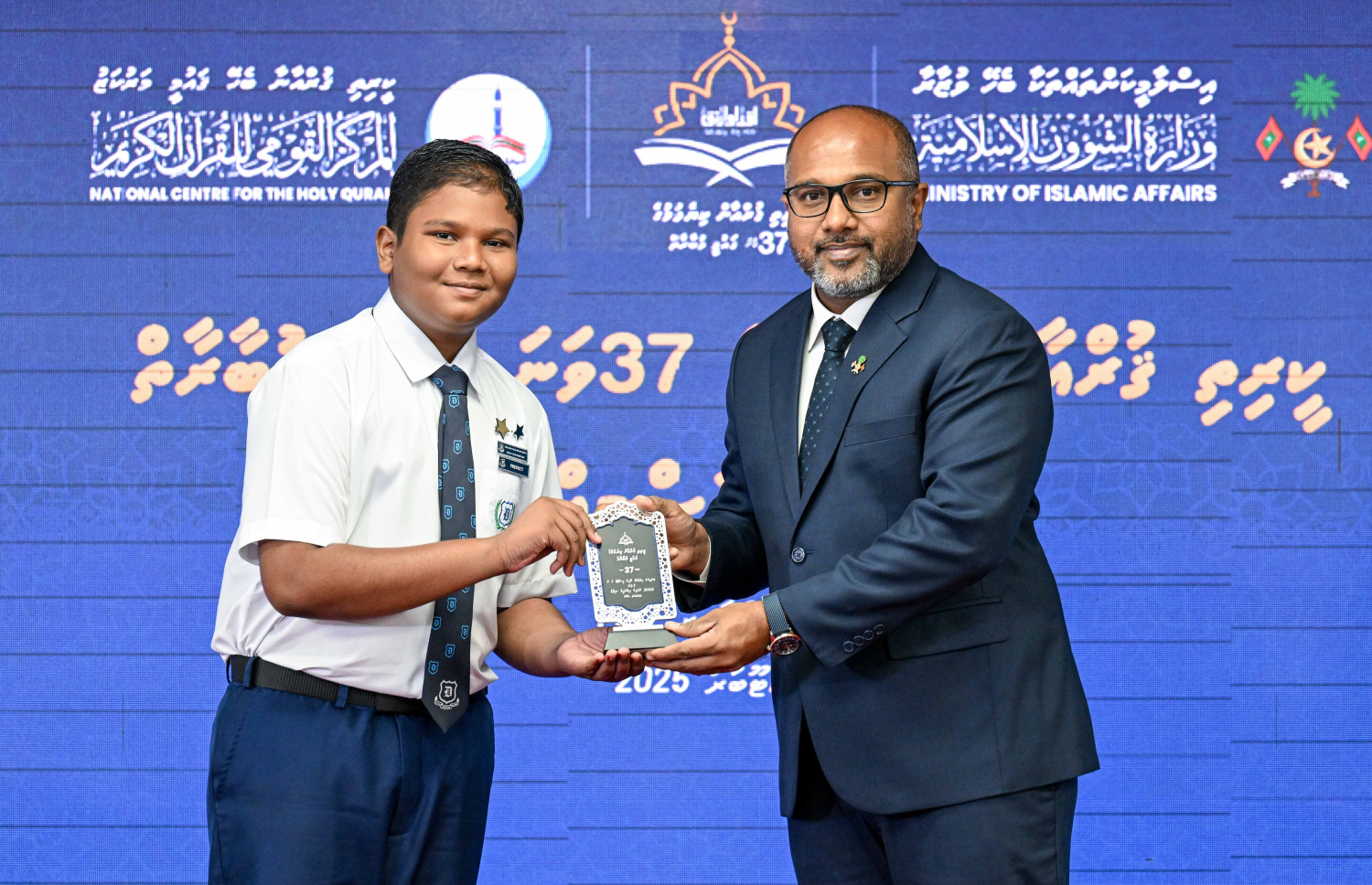 ޤުރުއާން ކިޔެވުމުގެ 37 ވަނަ ޤައުމީ މުބާރާތުގެ ވަނައަށް ހޮވުނު ދަރިވަރަކަށް ހޯމްލޭންޑް ސެކިއުރިޓީ މިނިސްޓަރު އަލީ އިހުސާން އިނާމް ހަވާލުކޮށްދެއްވަނީ --- ފޮޓޯ/ރައީސް އޮފީސް